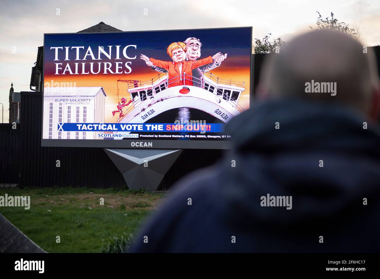 Glasgow, Schottland, Großbritannien. April 2021. IM BILD: Eine riesige elektronische Plakatwand, auf der eine Grafik mit dem Titel „TITANIC FAILURES“ und „TACTICAL VOTEE THE SNP OUT“ abgebildet ist, mit Comic-Figuren von Nicola Sturgeon und Alex Salmond, die die berühmte Szene aus dem Titanic am Bug nachspielen, aber stattdessen auf der Fähre von Glen Alba. Pressemitteilung Link: https://www.scotlandmatters.co.uk/titanicfailurebillboard/ Artikel Link: https://www.bbc.co.uk/news/amp/uk-scotland-glasgow-west-56579158?  twitter impression=true&s=03 Quelle: Colin Fisher/Alamy Live News. Stockfoto