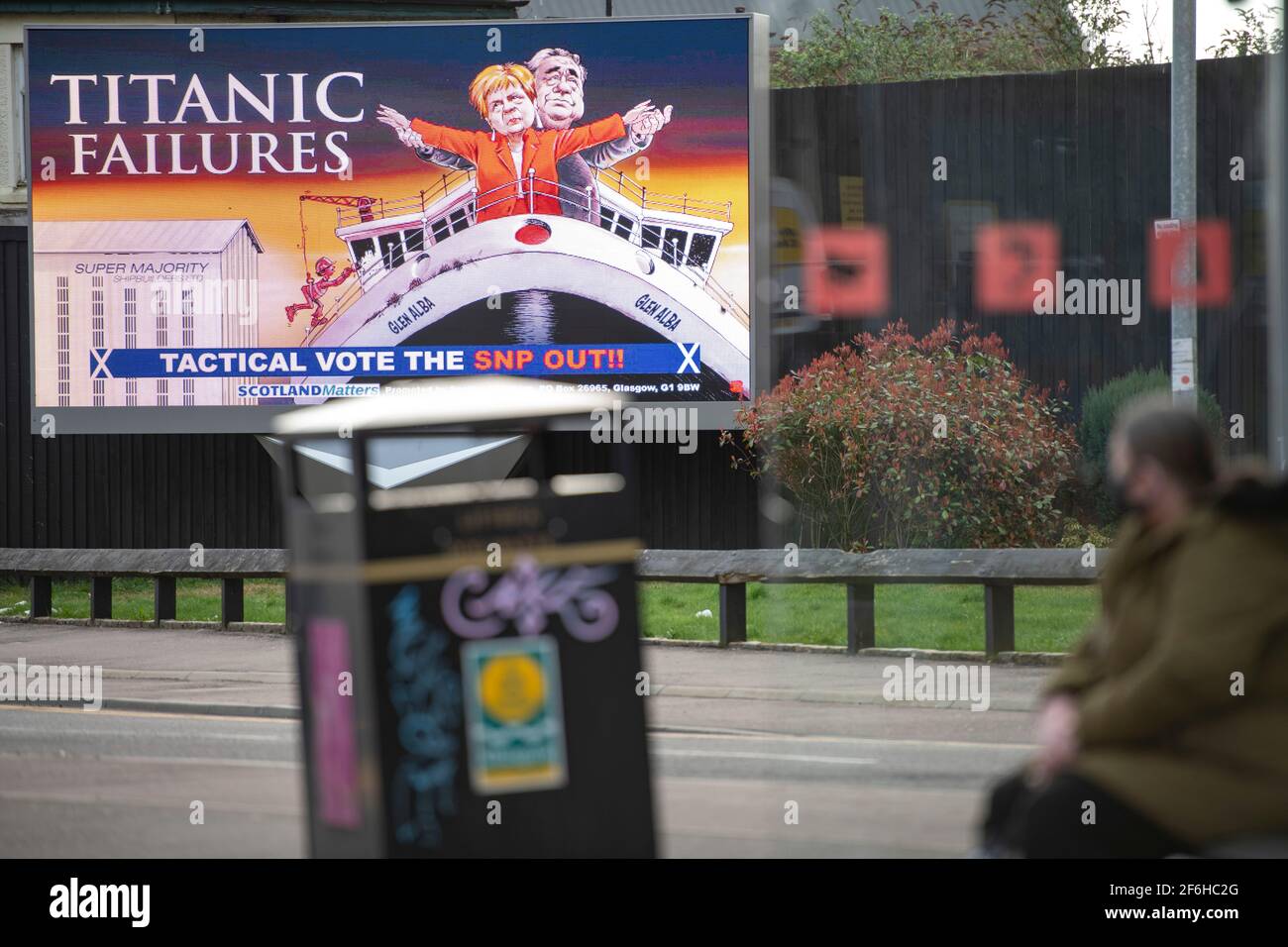Glasgow, Schottland, Großbritannien. April 2021. IM BILD: Eine riesige elektronische Plakatwand, auf der eine Grafik mit dem Titel „TITANIC FAILURES“ und „TACTICAL VOTEE THE SNP OUT“ abgebildet ist, mit Comic-Figuren von Nicola Sturgeon und Alex Salmond, die die berühmte Szene aus dem Titanic am Bug nachspielen, aber stattdessen auf der Fähre von Glen Alba. Pressemitteilung Link: https://www.scotlandmatters.co.uk/titanicfailurebillboard/ Artikel Link: https://www.bbc.co.uk/news/amp/uk-scotland-glasgow-west-56579158?  twitter impression=true&s=03 Quelle: Colin Fisher/Alamy Live News. Stockfoto