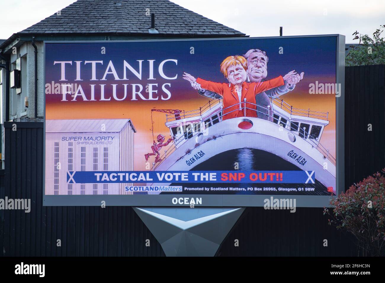 Glasgow, Schottland, Großbritannien. April 2021. IM BILD: Eine riesige elektronische Plakatwand, auf der eine Grafik mit dem Titel „TITANIC FAILURES“ und „TACTICAL VOTEE THE SNP OUT“ abgebildet ist, mit Comic-Figuren von Nicola Sturgeon und Alex Salmond, die die berühmte Szene aus dem Titanic am Bug nachspielen, aber stattdessen auf der Fähre von Glen Alba. Pressemitteilung Link: https://www.scotlandmatters.co.uk/titanicfailurebillboard/ Artikel Link: https://www.bbc.co.uk/news/amp/uk-scotland-glasgow-west-56579158?  twitter impression=true&s=03 Quelle: Colin Fisher/Alamy Live News Stockfoto