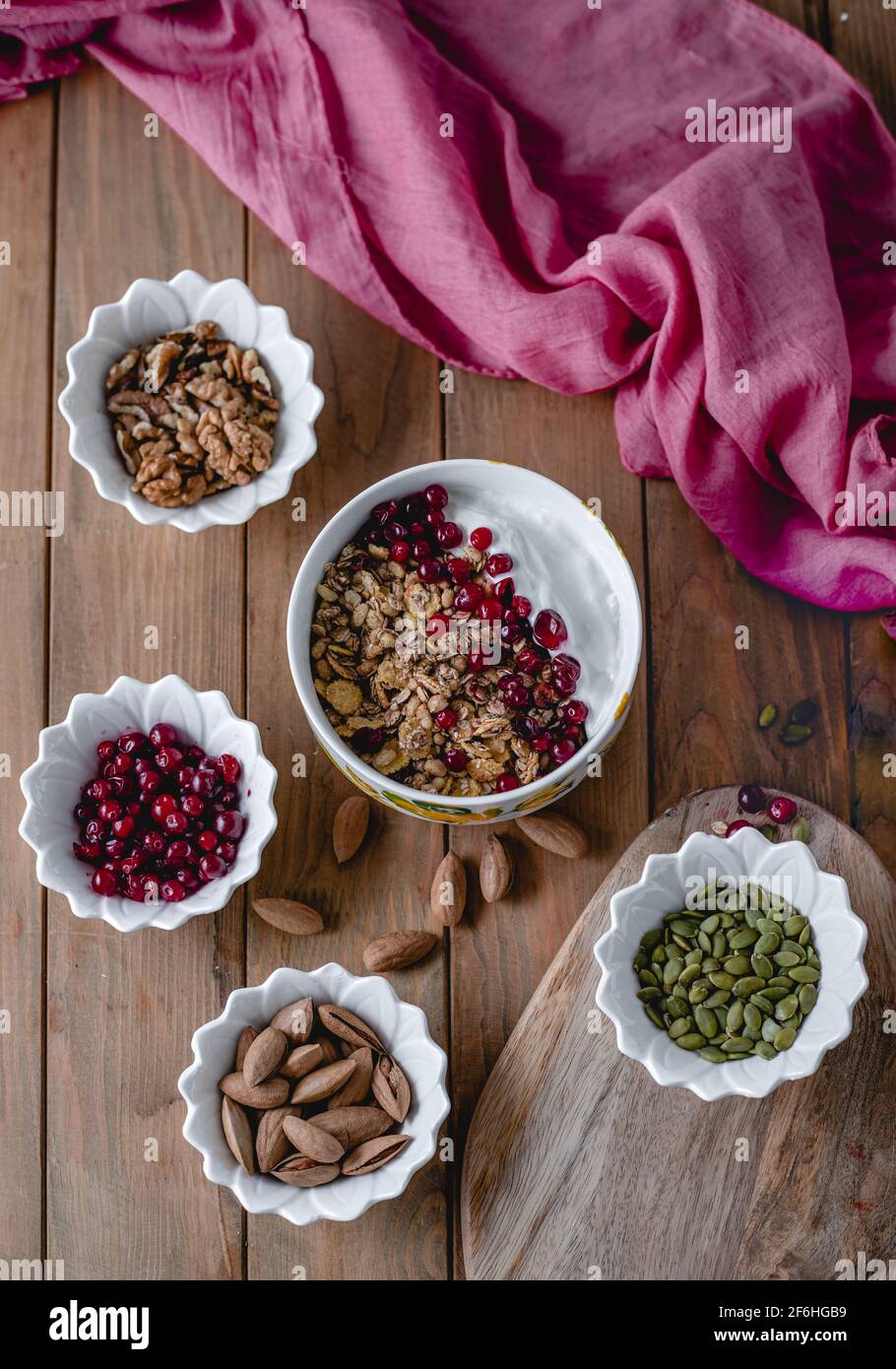 Gesunde Snacks. Vielfalt an Superfood: Nüsse, Beeren, Körner auf Holzgrund Stockfoto