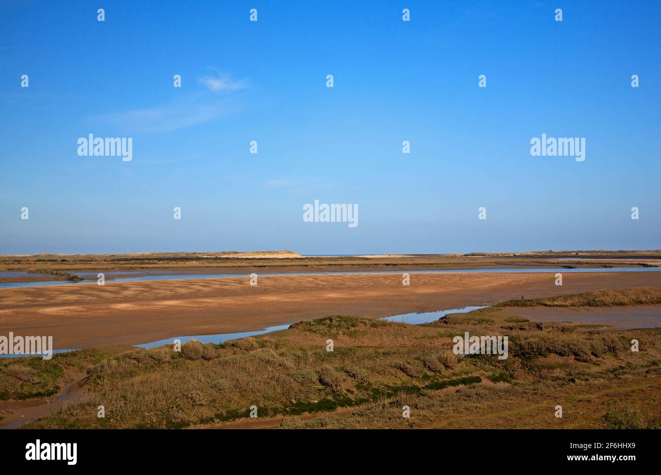 Ein Blick auf die Küstenstreifen an der Nord-Norfolk-Küste im Landesinneren von Dünen mit Flutbach bei Niedrigwasser in Burnham Overy, Norfolk, England, Großbritannien. Stockfoto