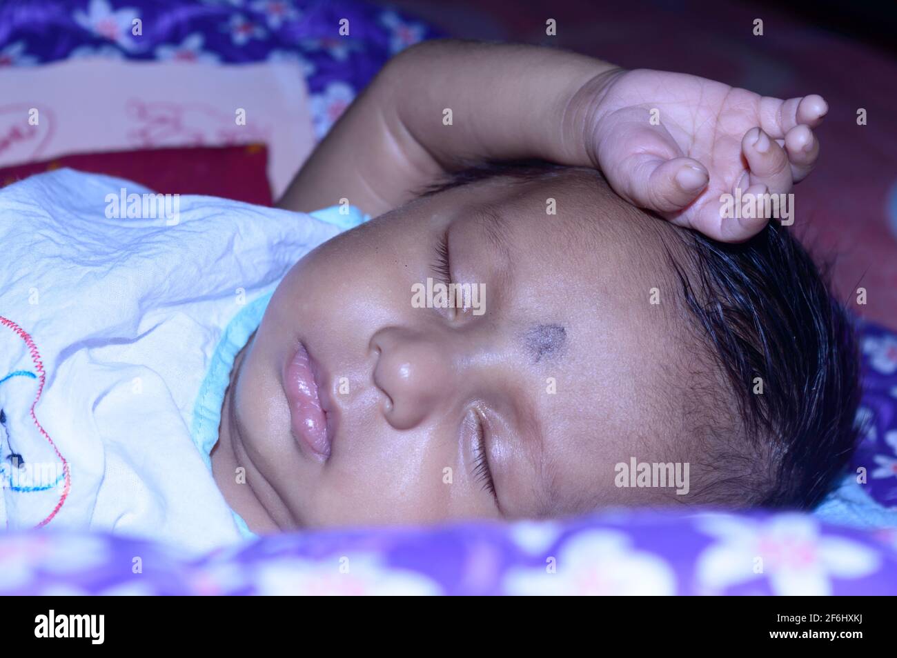 Nahaufnahme eines niedlichen schlafenden Neugeborenen. Nahaufnahme Porträt eines süßen gerade geborenen Jungen gefangen in schläfriger Stimmung schläfrige Augen. Hand auf Kopf. Fro Stockfoto