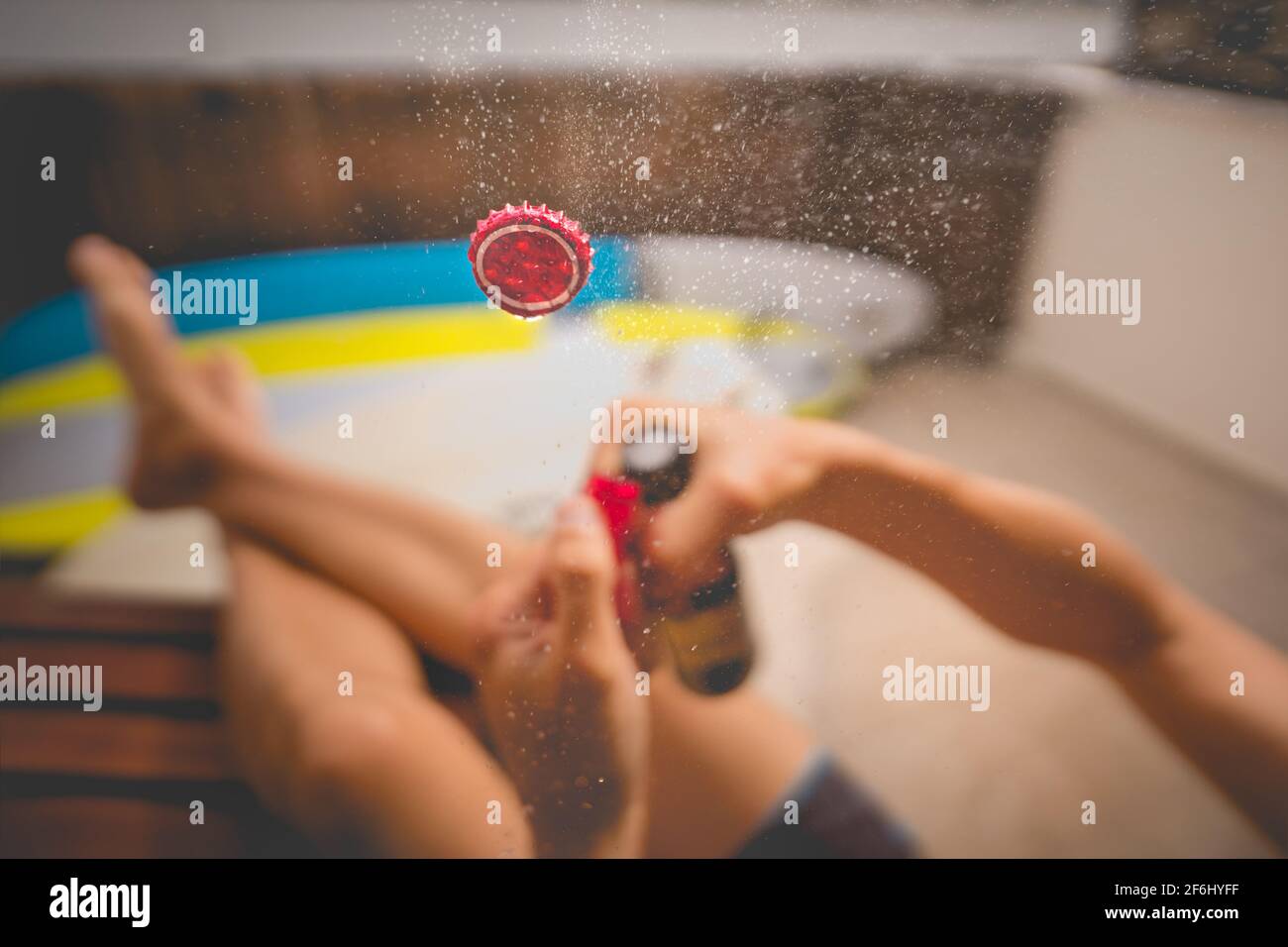 Kaltes Bier trinken und sonnigen Sommertag genießen. Flasche Bier mit Spritzer öffnen. Konzentrieren Sie sich auf die Kappe in der Luft. Stockfoto