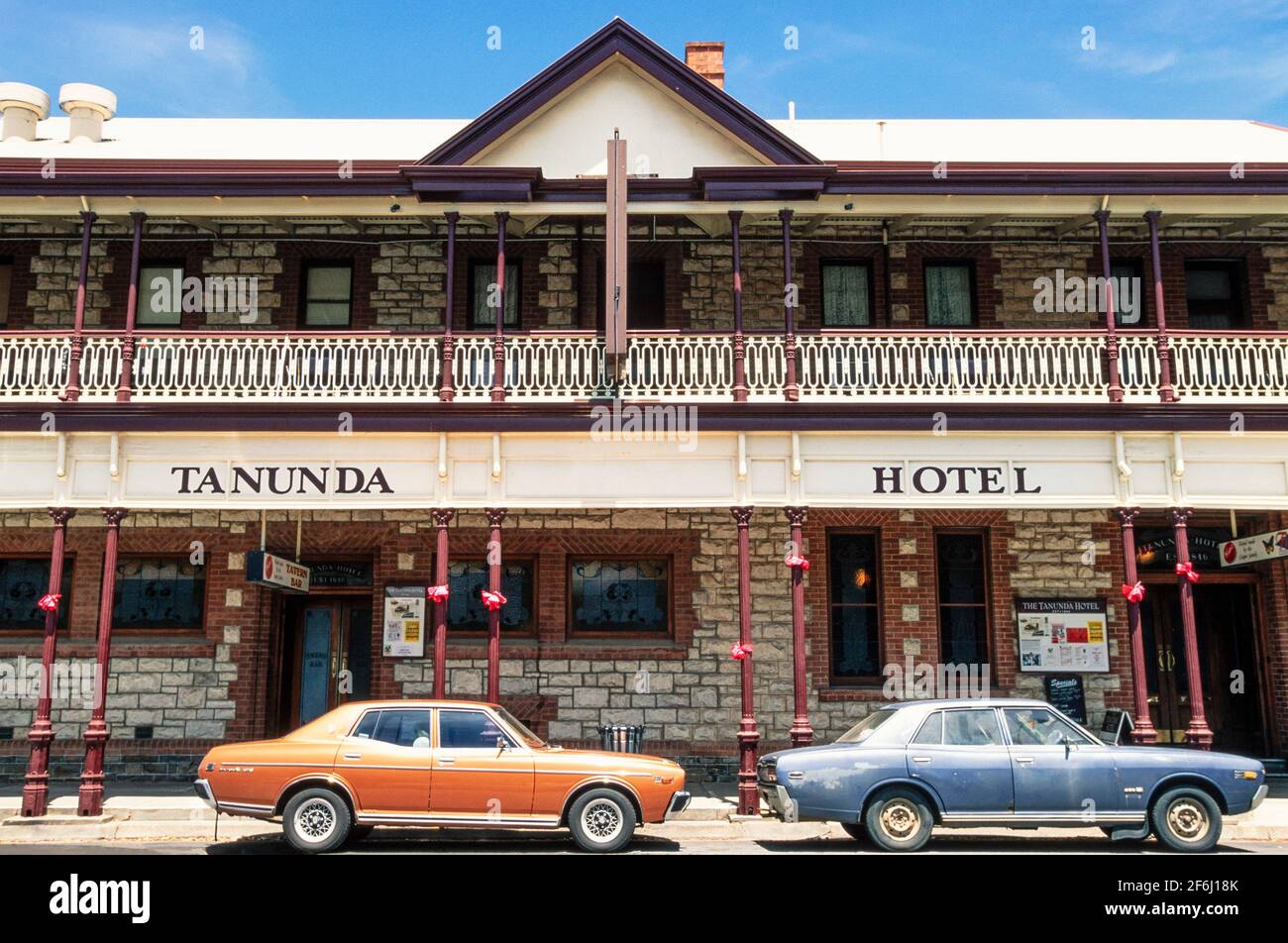2001 Tanunda - zwei Autos der 70er Jahre vor dem Tanunda Hotel, Tanunda, Barossa Valley, South Australia, Australien. Tanunda ist eine Stadt in der Region Barossa Valley in Südaustralien, 70 Kilometer nordöstlich der Landeshauptstadt Adelaide. Tanunda ist ein Wort der Aborigines für Wasserloch.das Barossa Valley ist eines der besten Weinanbaugebiete Australiens und die Stadt ist von Weinbergen umgeben. Dies ist eines der frühesten Gebäude der Stadt. Ein ehemaliges, feines Hotel, das 1846 aus lokalem Stein erbaut wurde, hat sich im Laufe der Jahre verändert, mit einem zweiten Stock und einer englischen Eisenhütte Veranda. Stockfoto