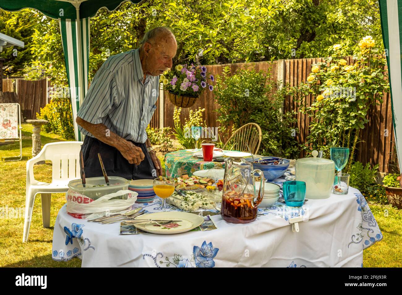 Familie Sommer authentischer Garten Mittagessen Picknick Zusammen mit Opa, der sich selbst mit köstlichen hausgemachten gekochten Gerichten serviert, London England Stockfoto