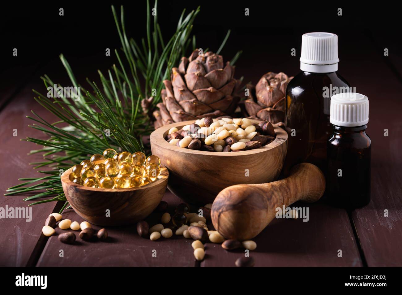 Naturprodukt Zedernnussöl mit Glasflaschen und Zapfen Auf einem Holztisch Stockfoto