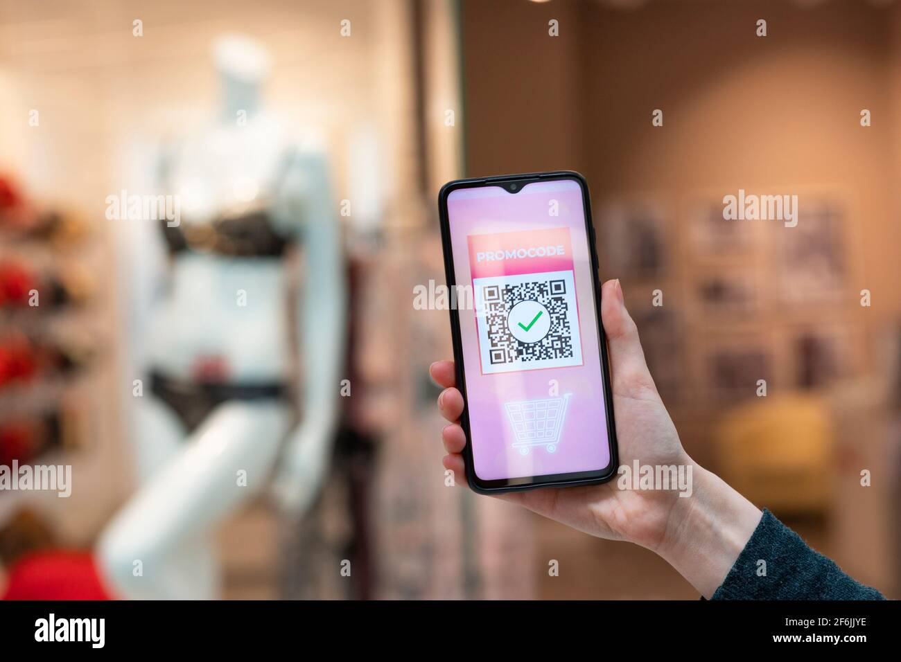 Eine Frau hält ein Handy mit einem qr-Code für einen Rabatt im Internet-Shop. Das Konzept des Internet-Shoppings. Stockfoto