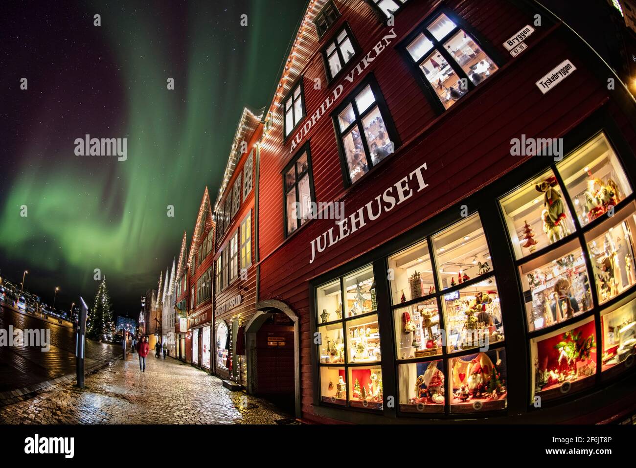 Weihnachtseinkäufe in den Geschäftsgebäuden von Bryggen am Hafen von Vagen, Bergen, Norwegen. Zusammengesetztes Bild von aurora. Stockfoto