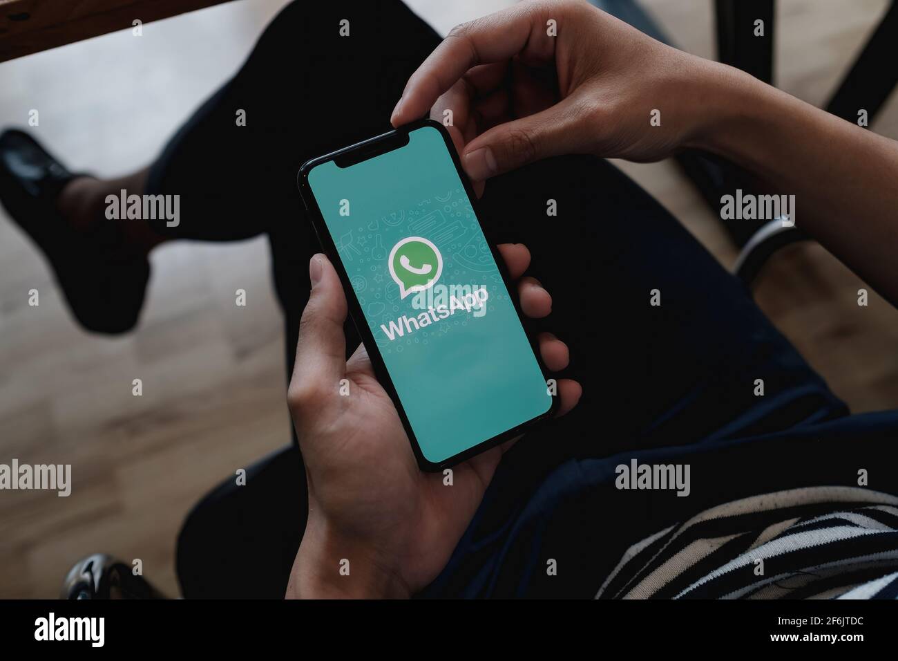 CHIANG MAI, THAILAND - JAN 23, 2021 : Aan mit einem iPhone x und öffnen sie appstore, der den sozialen Internetdienst WhatsApp auf dem Bildschirm durchsucht Stockfoto