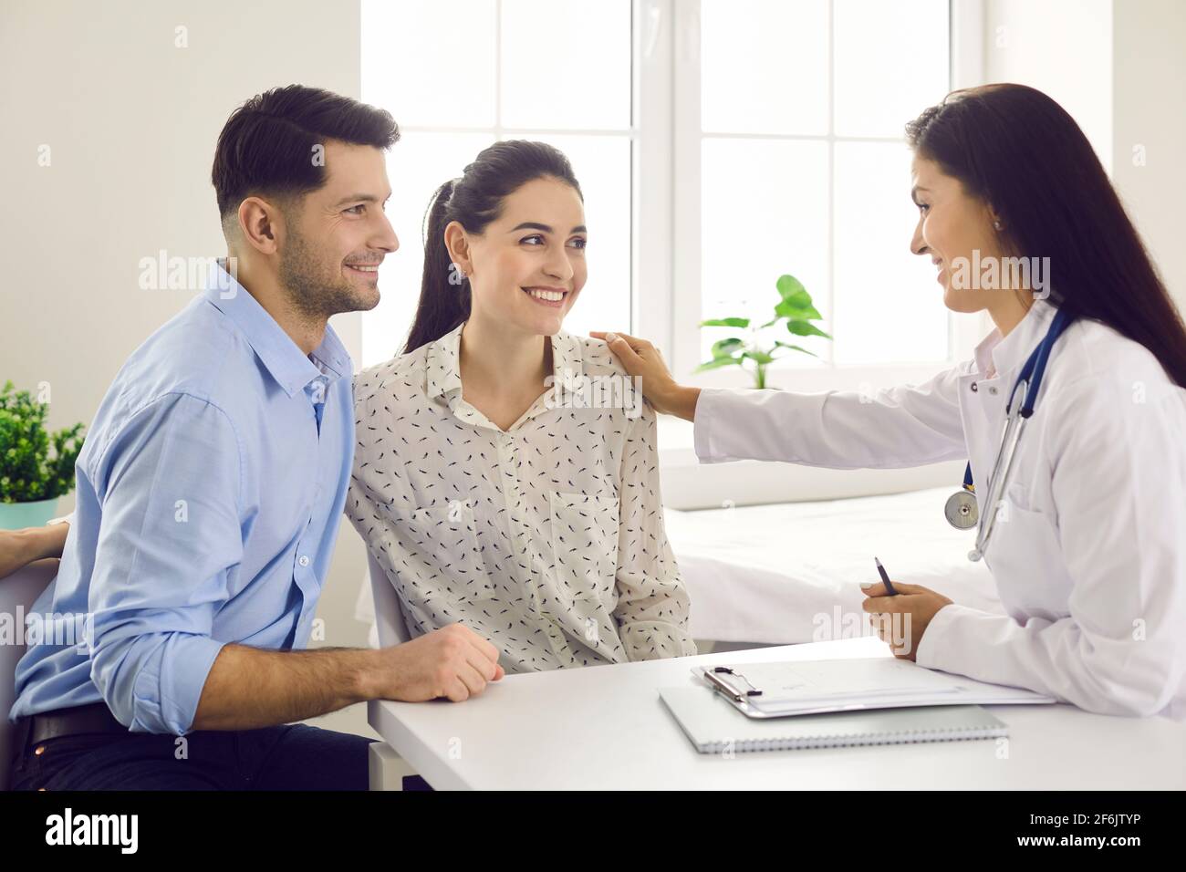 Weibliche Ärztin, die junge Paare in der Fruchtbarkeitsklinik über IVF oder IUI berät. Stockfoto