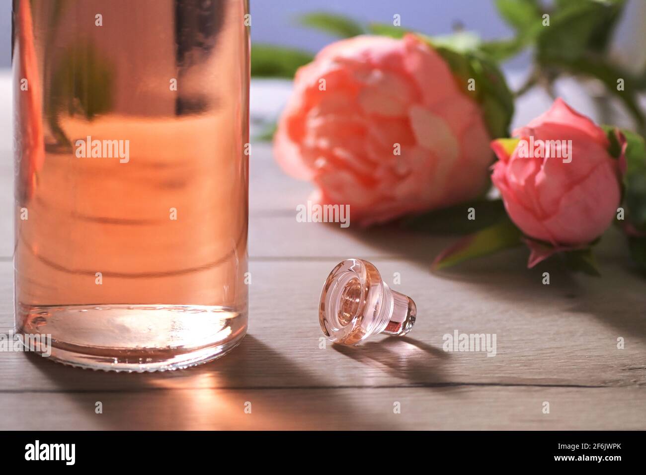 Nahaufnahme Flasche rosa Rosenwein und Frühlingsblumen Stockfoto