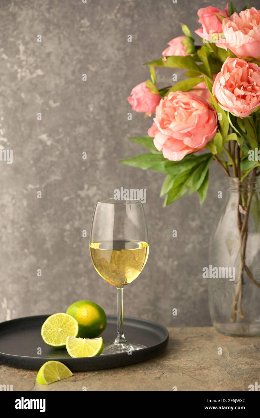 Nahaufnahme Glas Weißwein und Pfingstrosen Stockfoto