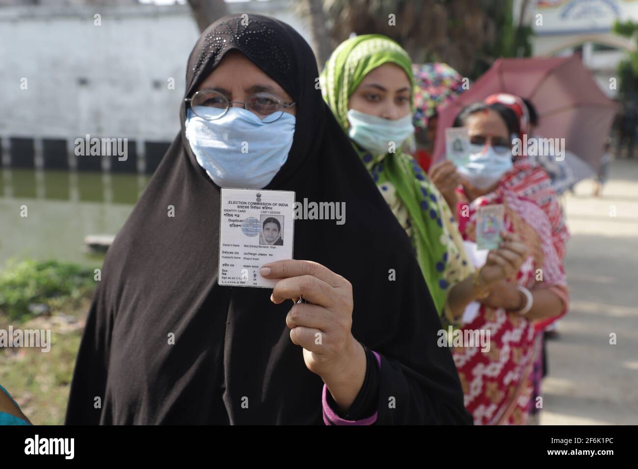 Nandigram, Indien. April 2021. Eine muslimische Frau zeigt ihren Wählerausweis, während sie in einer Schlange vor einem Wahlschalter in East Midnapur steht.die Wähler von Nandigram haben ihre Stimme während der zweiten Phase der Parlamentswahlen in Westbengalen abgegeben, die von schweren bewaffneten Zentraltruppen eingesetzt wurden, um die Wahlen friedlich zu gestalten. (Foto von JIT Chattopadhyay/SOPA Images/Sipa USA) Quelle: SIPA USA/Alamy Live News Stockfoto