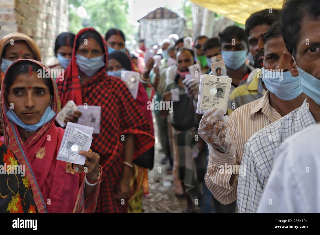 Nandigram, Indien. April 2021. Menschen, die ihre Wählerausweise vorzeigen, während sie in Warteschlangen vor einem Wahlstand in East Midnapur warten.die Wähler von Nandigram haben während der zweiten Phase der Parlamentswahlen in Westbengalen ihre Stimme abgegeben, um die Wahlen friedlich zu gestalten. (Foto von JIT Chattopadhyay/SOPA Images/Sipa USA) Quelle: SIPA USA/Alamy Live News Stockfoto