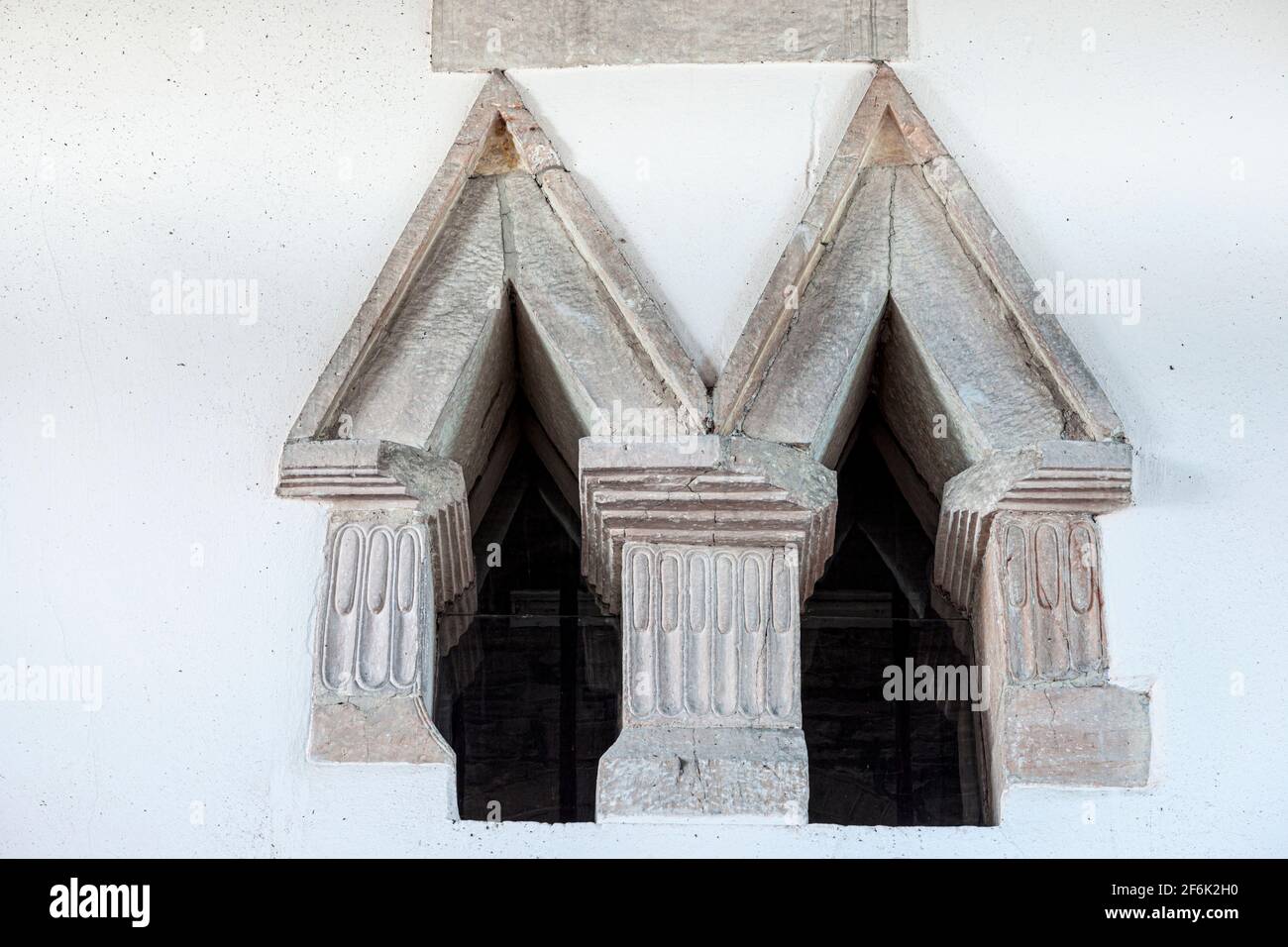 Einzigartiges doppeltes, dreieckiges sächsisches Fenster in der angelsächsischen Prioritätenkirche St. Mary aus dem 9. Jahrhundert in Deerhurst, Gloucestershire Stockfoto