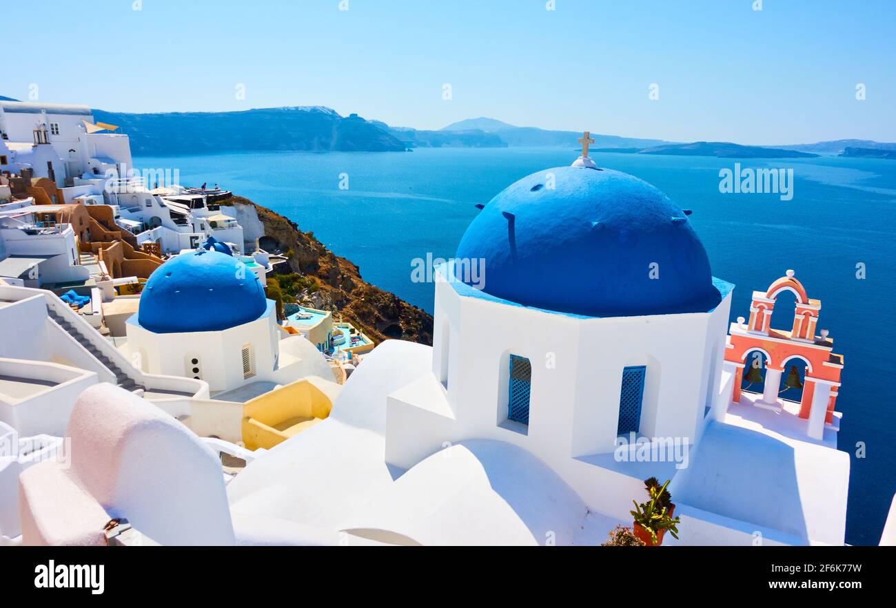 Griechenland, Santorini. Malerische Aussicht mit blauen Kuppeln der alten griechischen Kirche am Meer in Oia Stockfoto