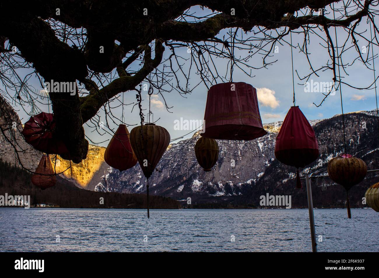 Ein Baum mit Papierlaternen mit Hallstätter See und Bergen Im Hintergrund Stockfoto