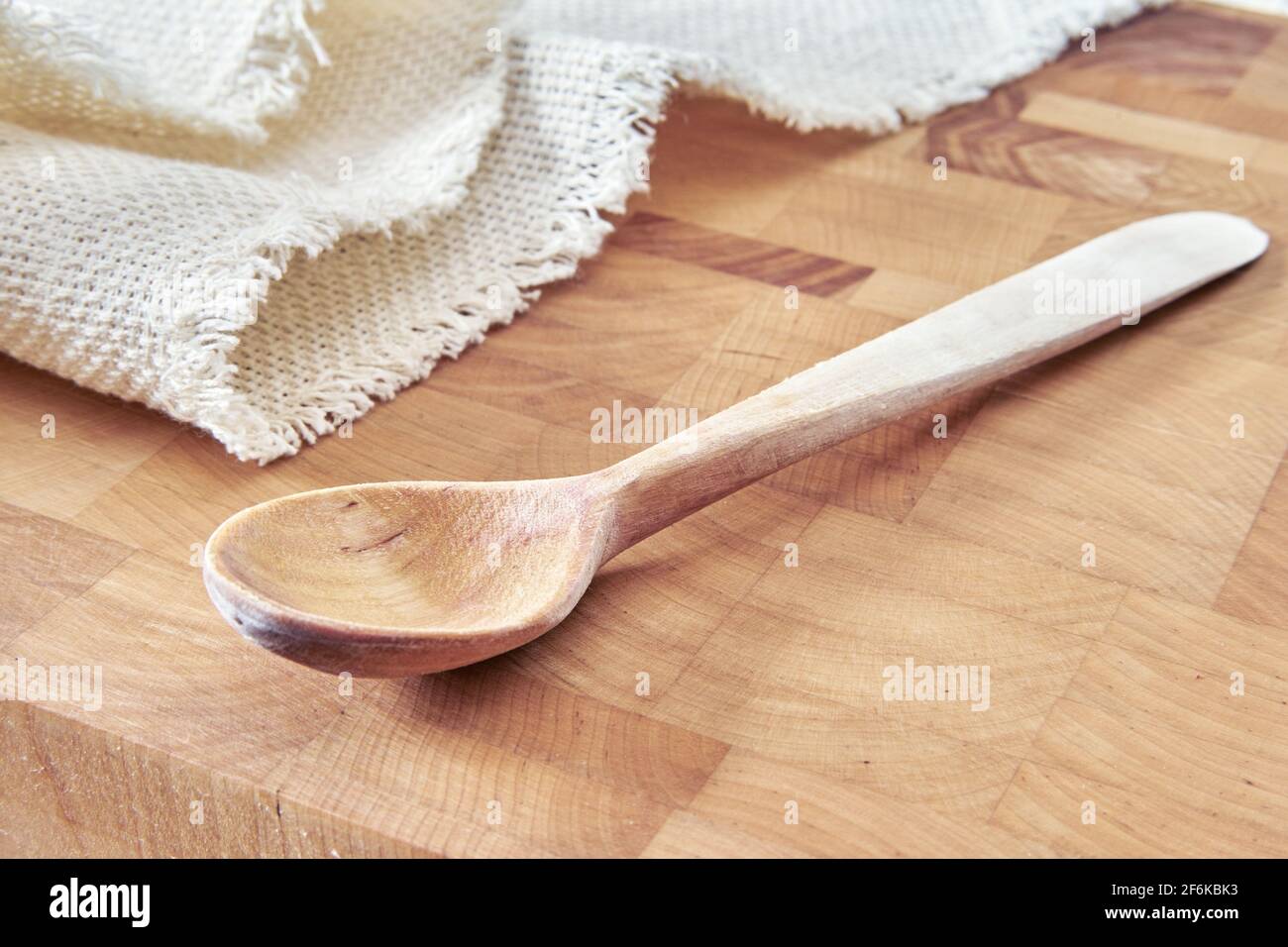 Holzlöffel und Serviette auf Schneidebrett Stockfoto