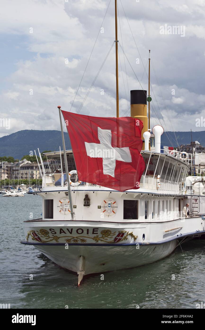 schweizer Flagge auf dem Heck eines alten Dampfschiffes im Hafen mit dem Wasserstrahl in Genf, Schweiz Stockfoto