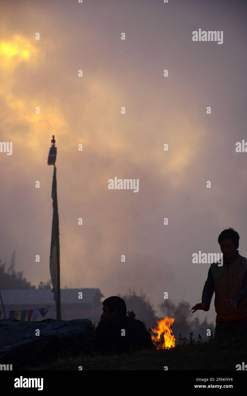 Kaltes und düsteres Wetter, brennendes Feuer und Gebetsfahne Stockfoto