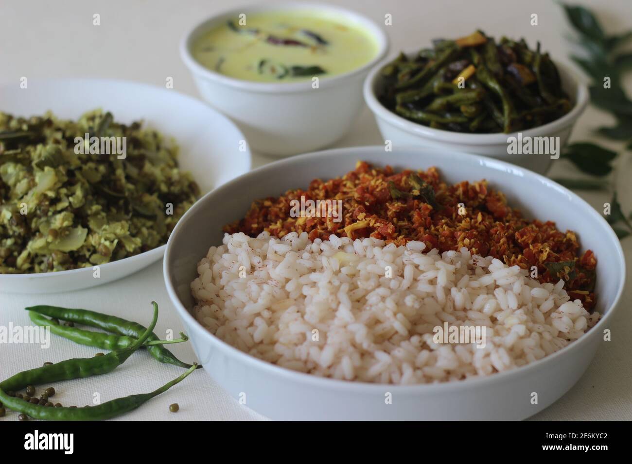 Vegetarisches Essen im Kerala-Stil, einschließlich gekochtem matta-Reis, rotem Karotten-Thoran, Bohnen-Rührbraten, grüner Gramm-Flasche Kürbis-Thoran und temperierter Buttermilch. Aufgenommen Stockfoto