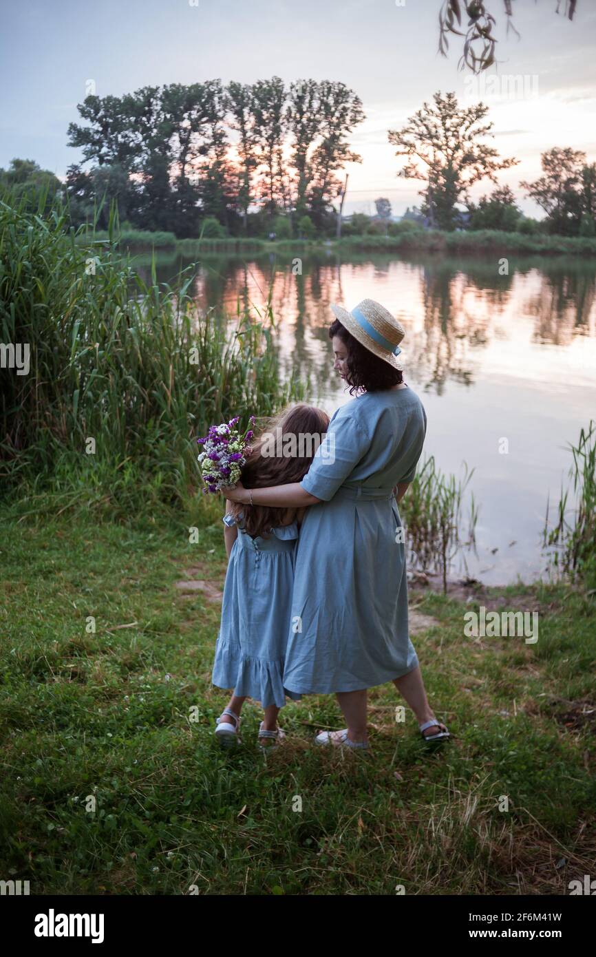 Die Mutter umarmt ihre Tochter im Freien in der Natur Stockfoto