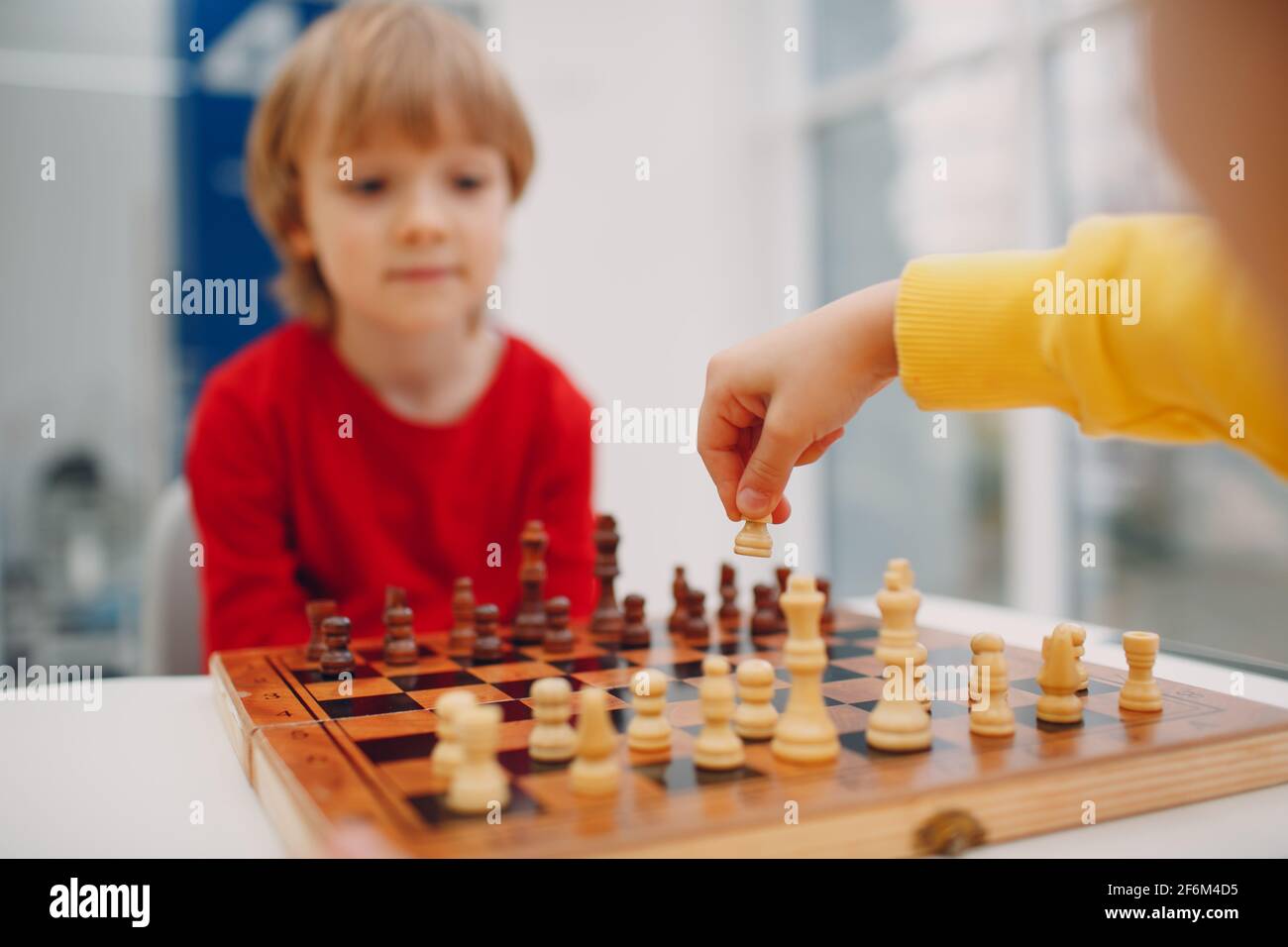 Kleine Kinder spielen Schach im Kindergarten oder in der Grundschule. Kinderschachspiel Stockfoto