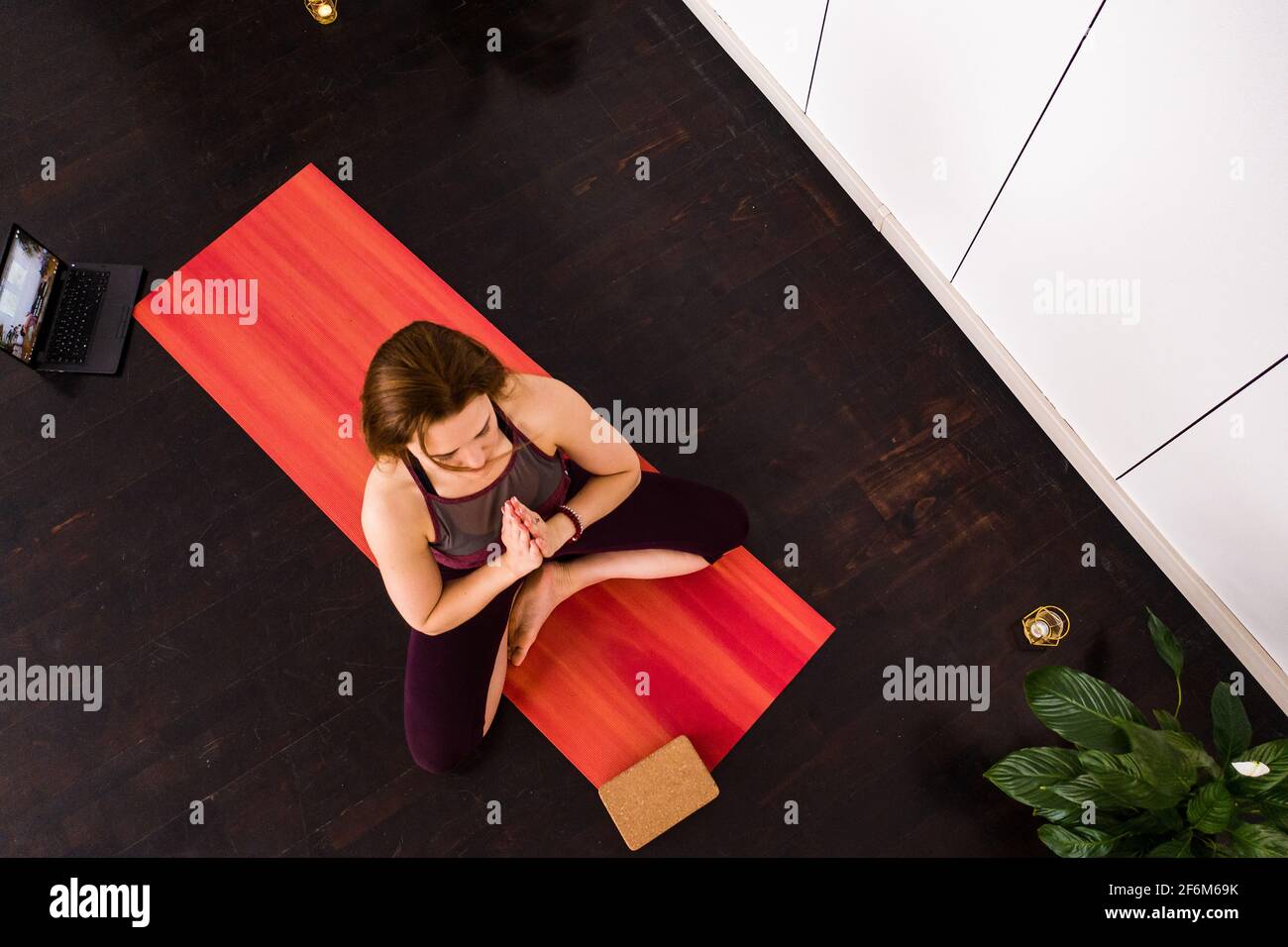Draufsicht auf die schöne junge Fitness-Frau, die auf Holzboden trainiert, Yoga-Übungen macht, in voller Länge Stockfoto