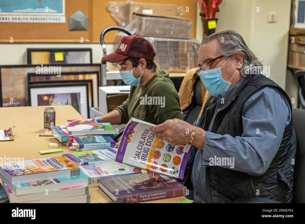 Denver, Colorado - EIN Käufer von gebrauchten Lehrbüchern schaut sich Bücher an, die ein Pflegestudent am Denver College of Nursing anbietet. Bücher, die haben Stockfoto