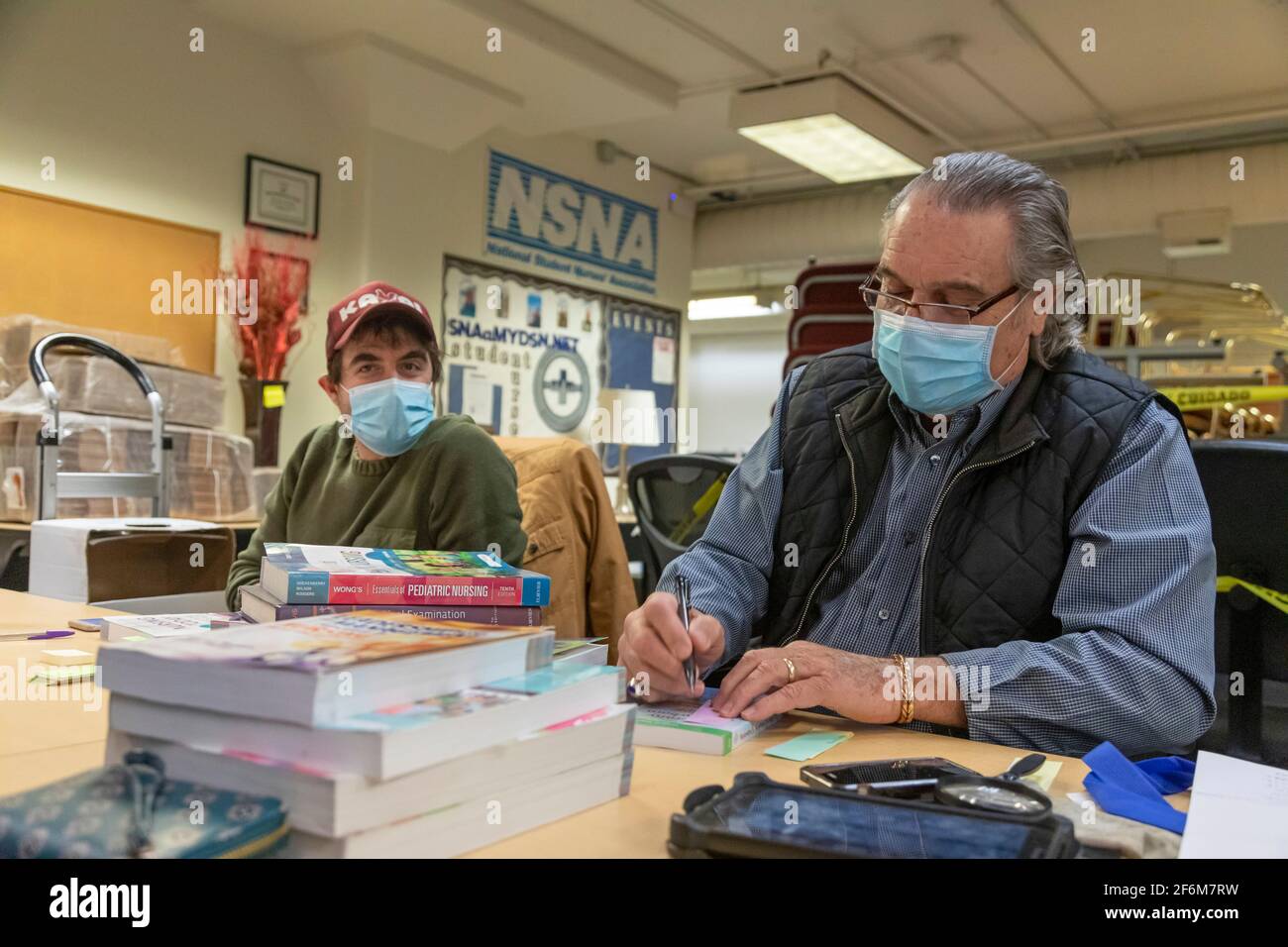 Denver, Colorado - EIN Käufer von gebrauchten Lehrbüchern schaut sich Bücher an, die ein Pflegestudent am Denver College of Nursing anbietet. Bücher, die haben Stockfoto