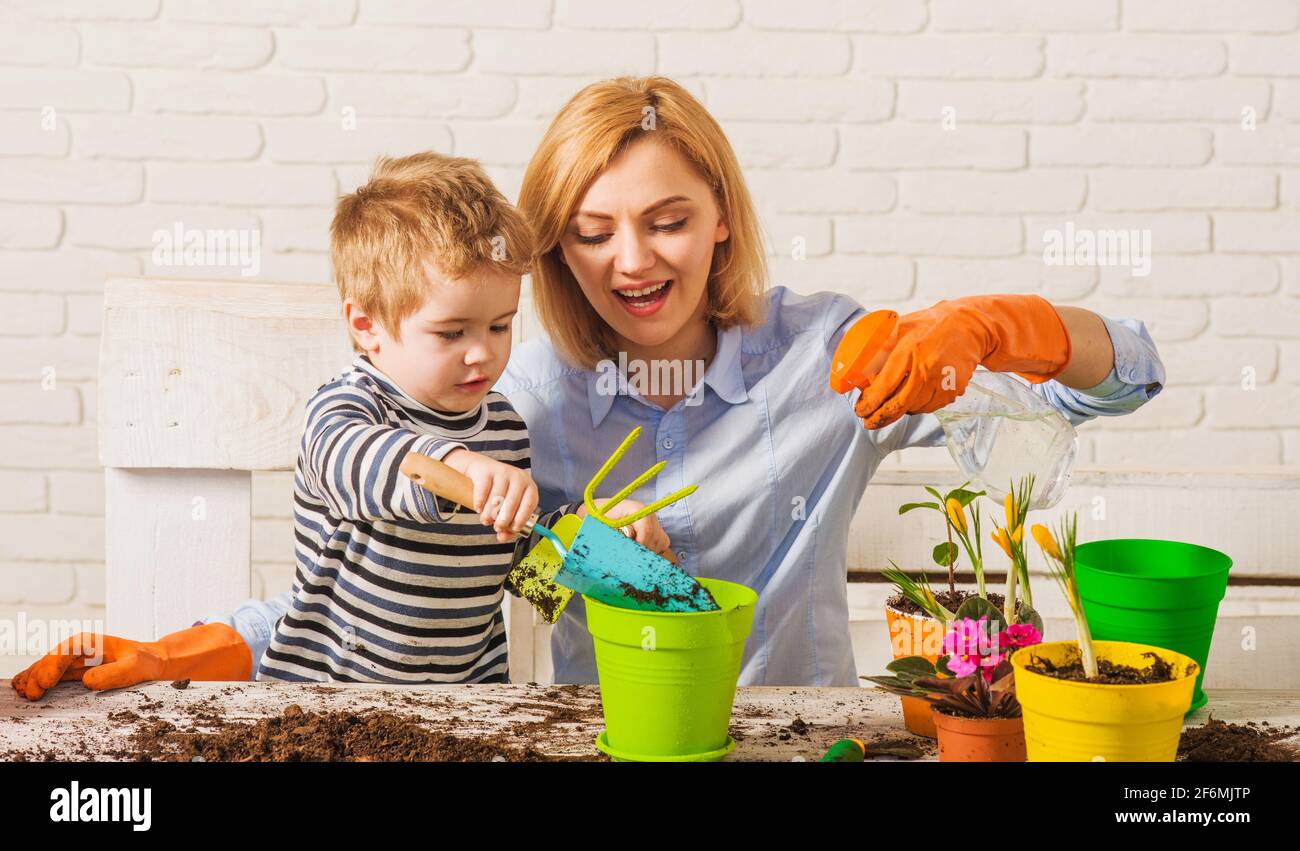 Frühling. Mutter mit kleinem Sohn, der Blume pflanzt. Familienbeziehungen. Pflege der Pflanzen. Gartenarbeit. Stockfoto