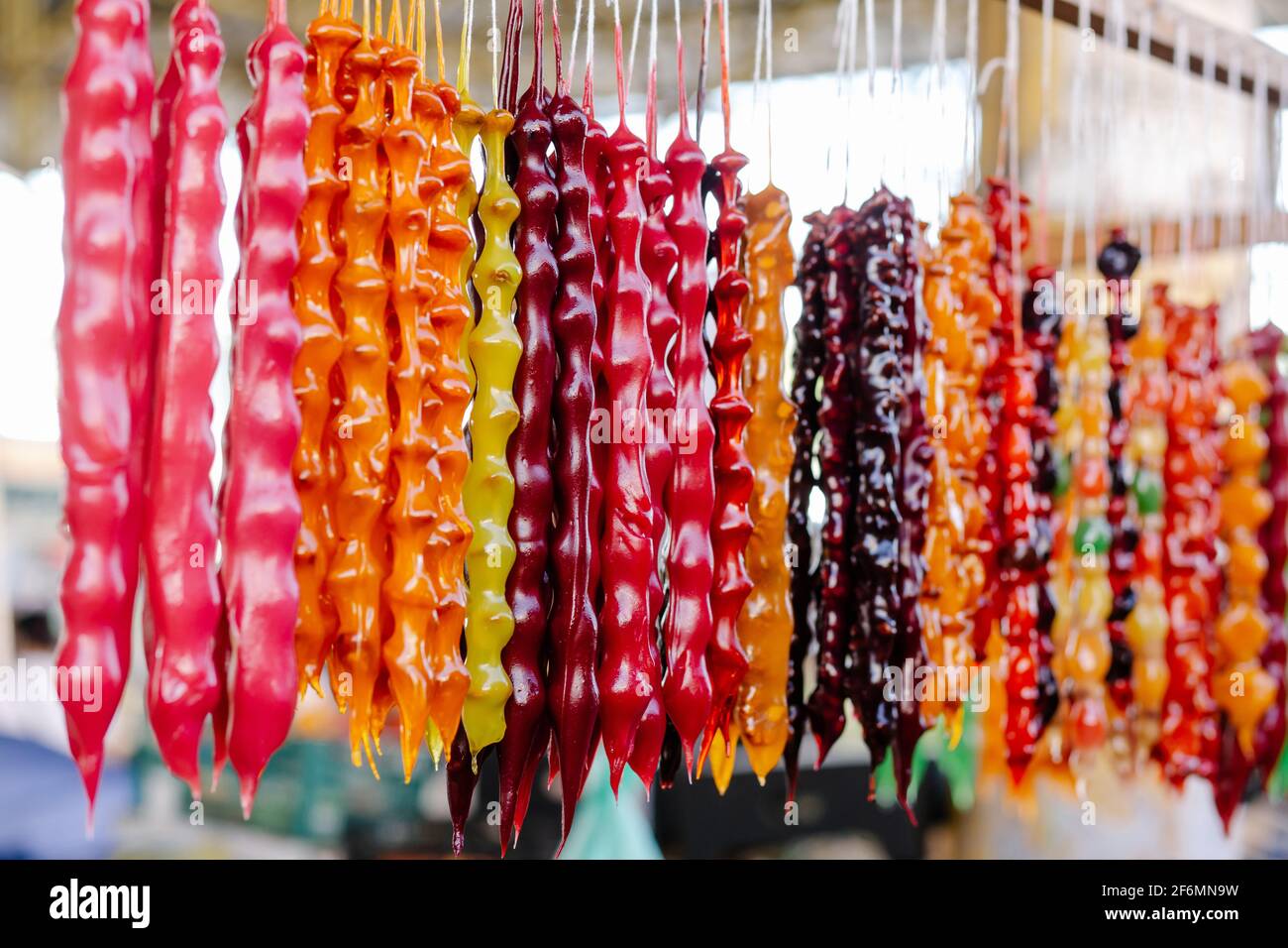 Bunte hausgemachte Süßigkeiten Churchkhela mit Haselnüssen, Walnüssen, Traubensaft, Honig oder Zucker, Weizen oder Maismehl. Dessert in lokalen Lebensmittelmarkt verkauft. Stockfoto