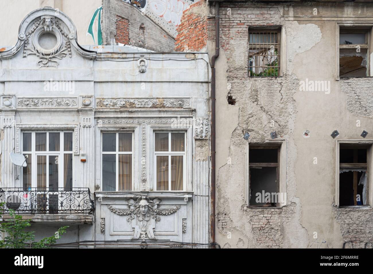 Zwei kontrastierende, neue (zerrissene Fenster) und alte (jugendstil oder modern, gut erhalten) Gebäude nebeneinander, in Bukarest, Rumänien Stockfoto