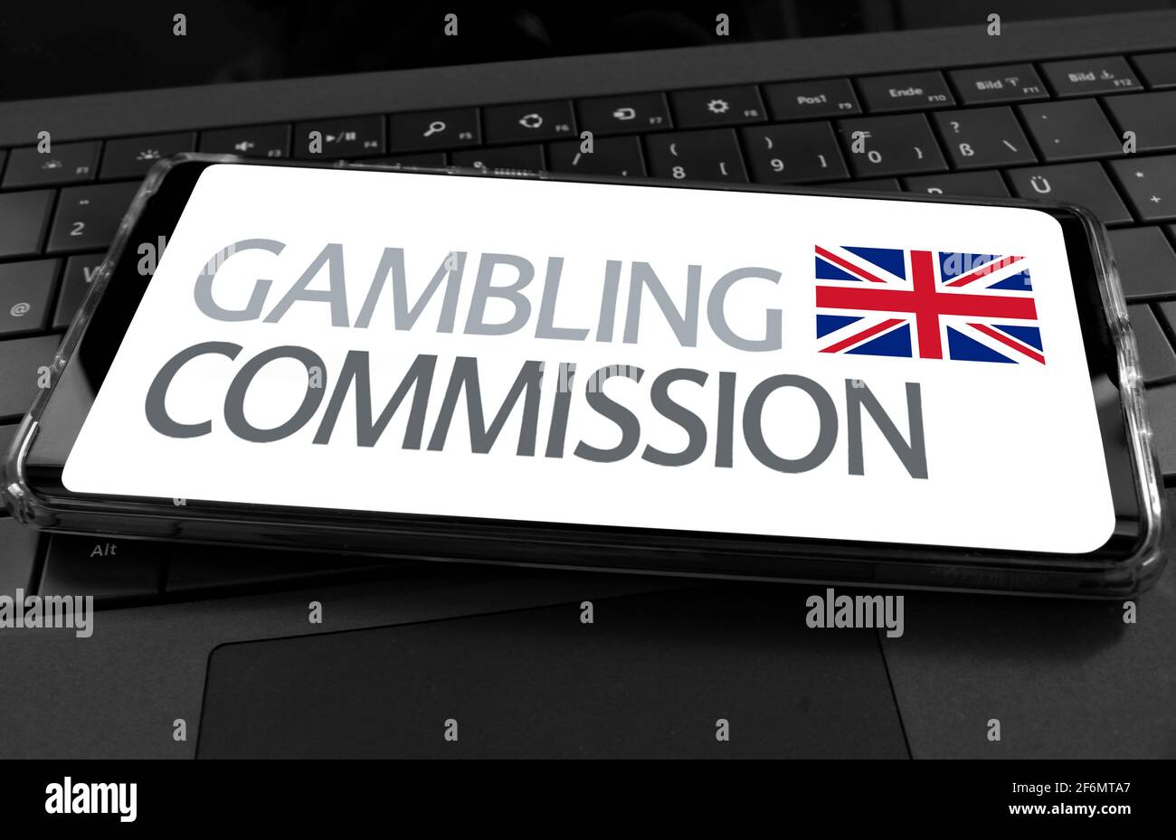 Nahaufnahme des Mobiltelefons mit Schriftzug Gambling Commission Lizenzierung Autorität und britische Flagge Stockfoto