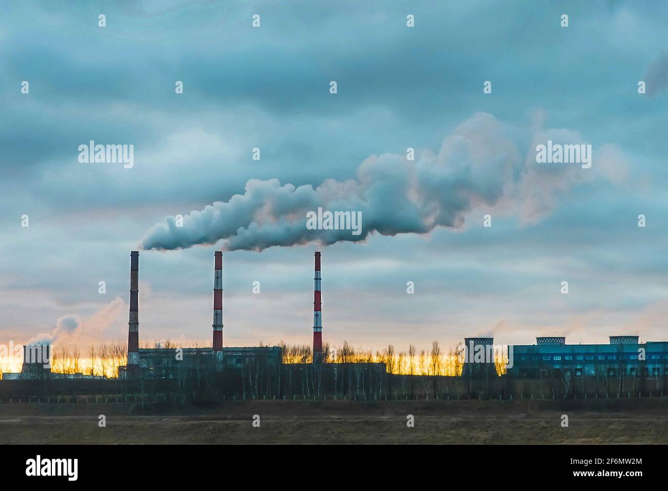 Umweltverschmutzung, Umweltprobleme, Rauch aus dem Schornstein einer Industrieanlage oder eines thermischen Kraftwerks gegen einen wolkigen blauen Himmel. Stockfoto