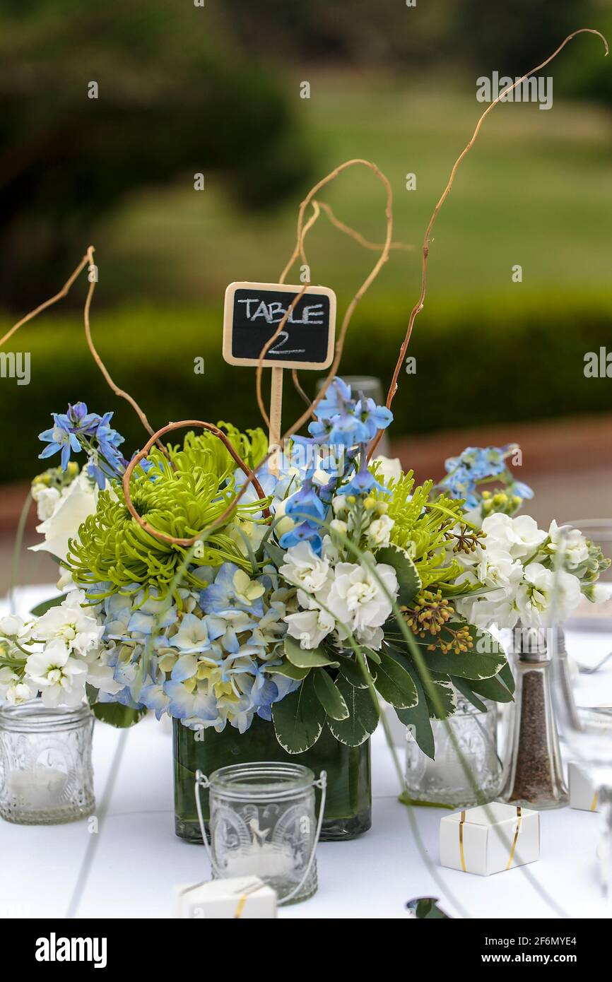 Weiße Tischdecken für einen Hochzeitsempfang im Freien mit Blaue Blumen als Dekor Stockfoto