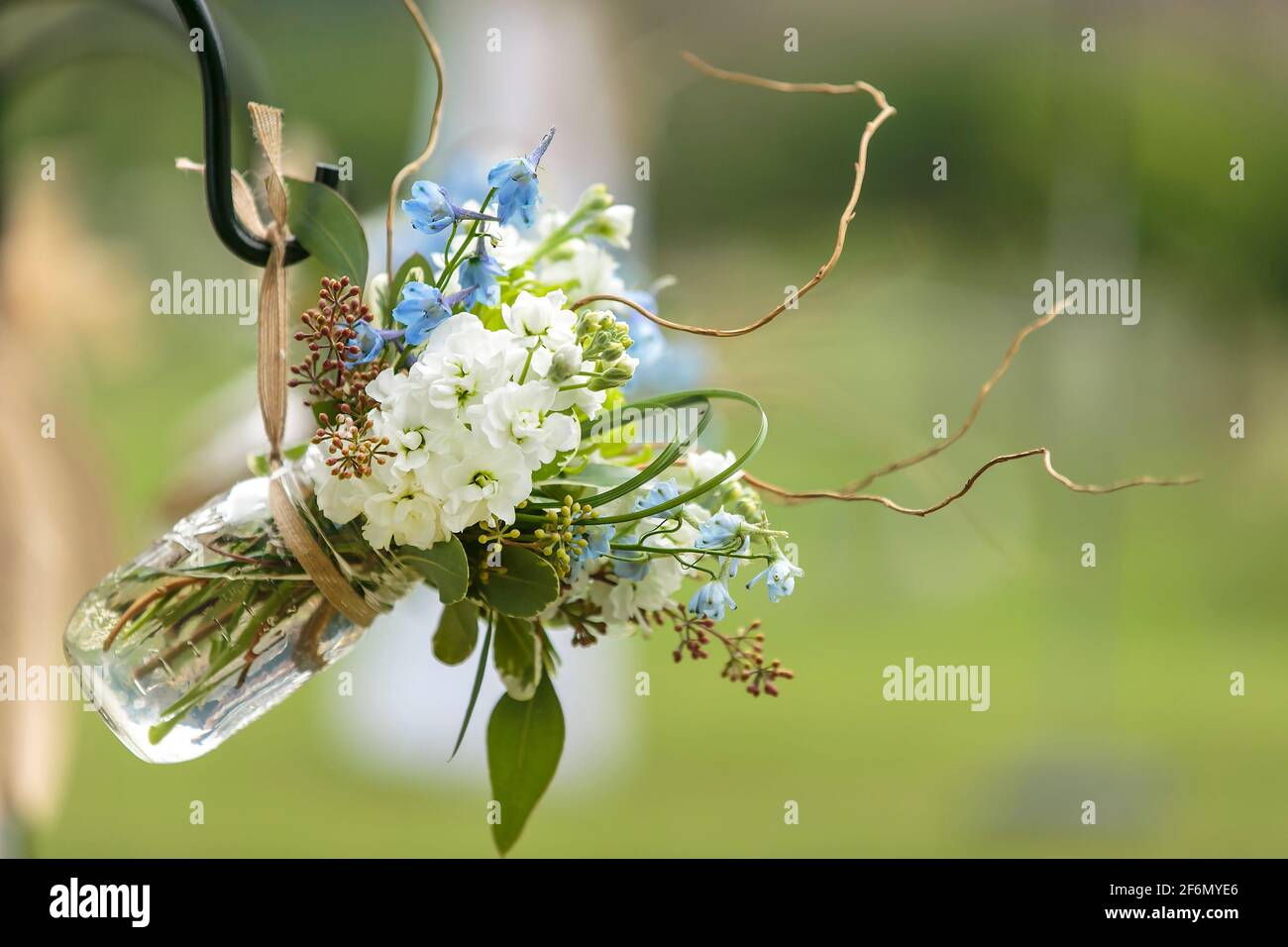 Blaue und weiße Blumen in Maurergefäßen als Dekor für Sitzplätze enden bei einer Hochzeitszeremonie Stockfoto