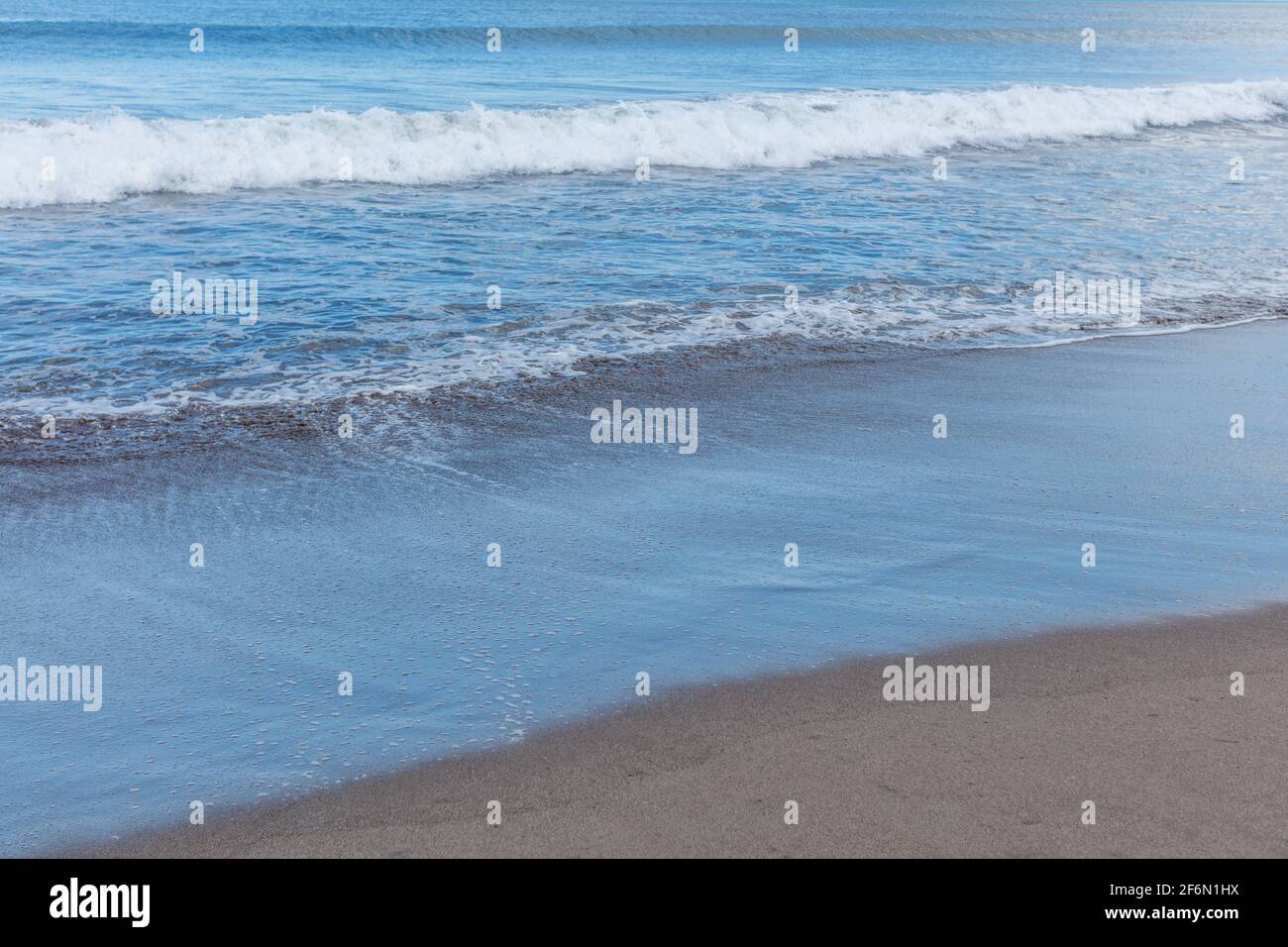 Batu Belig Beach (Pantai Batu Belig), Badung, Bali, Indonesien. Grauer Sand, Meereswellen. Stockfoto