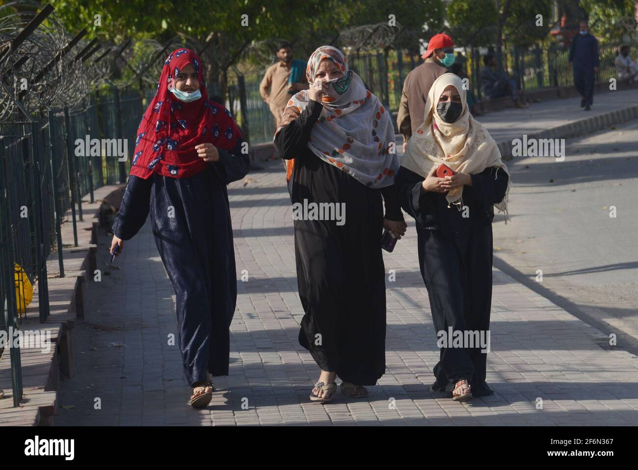 Lahore, Pakistan. April 2021. Pakistanische Familienmitglieder reisen zu Fuß, weil sie wegen der Schließung von Speedo-Bussen und der Orange Line Metro Train (OLMT) wegen neuer Beschränkungen, die die Ausbreitung des Covid-19 in der Provinzhauptstadt Lahore eindämmen, Schwierigkeiten haben. (Foto von Rana Sajid Hussain/Pacific Press) Quelle: Pacific Press Media Production Corp./Alamy Live News Stockfoto