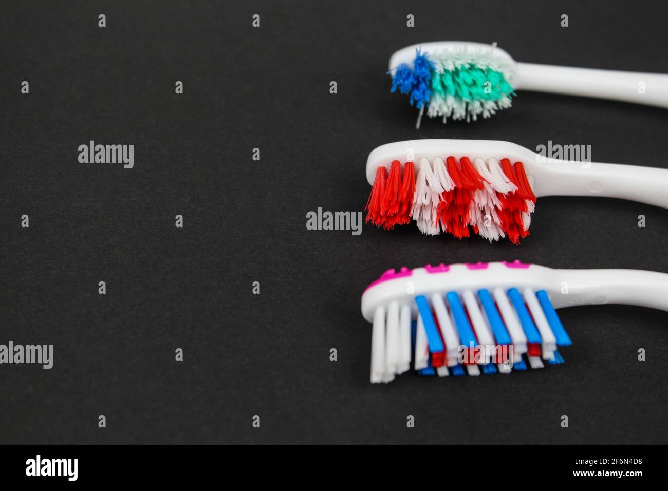 Bunte Zahnbürste von oben auf schwarzem Hintergrund geschossen. Minimalistisches Bild Stockfoto