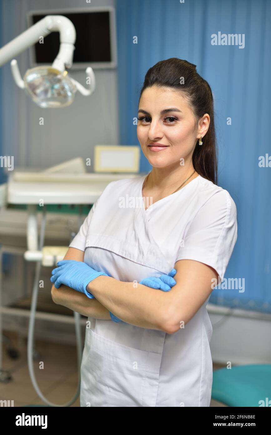 Porträt einer jungen Frau Zahnarzt steht an seinem Arbeitsplatz Stockfoto