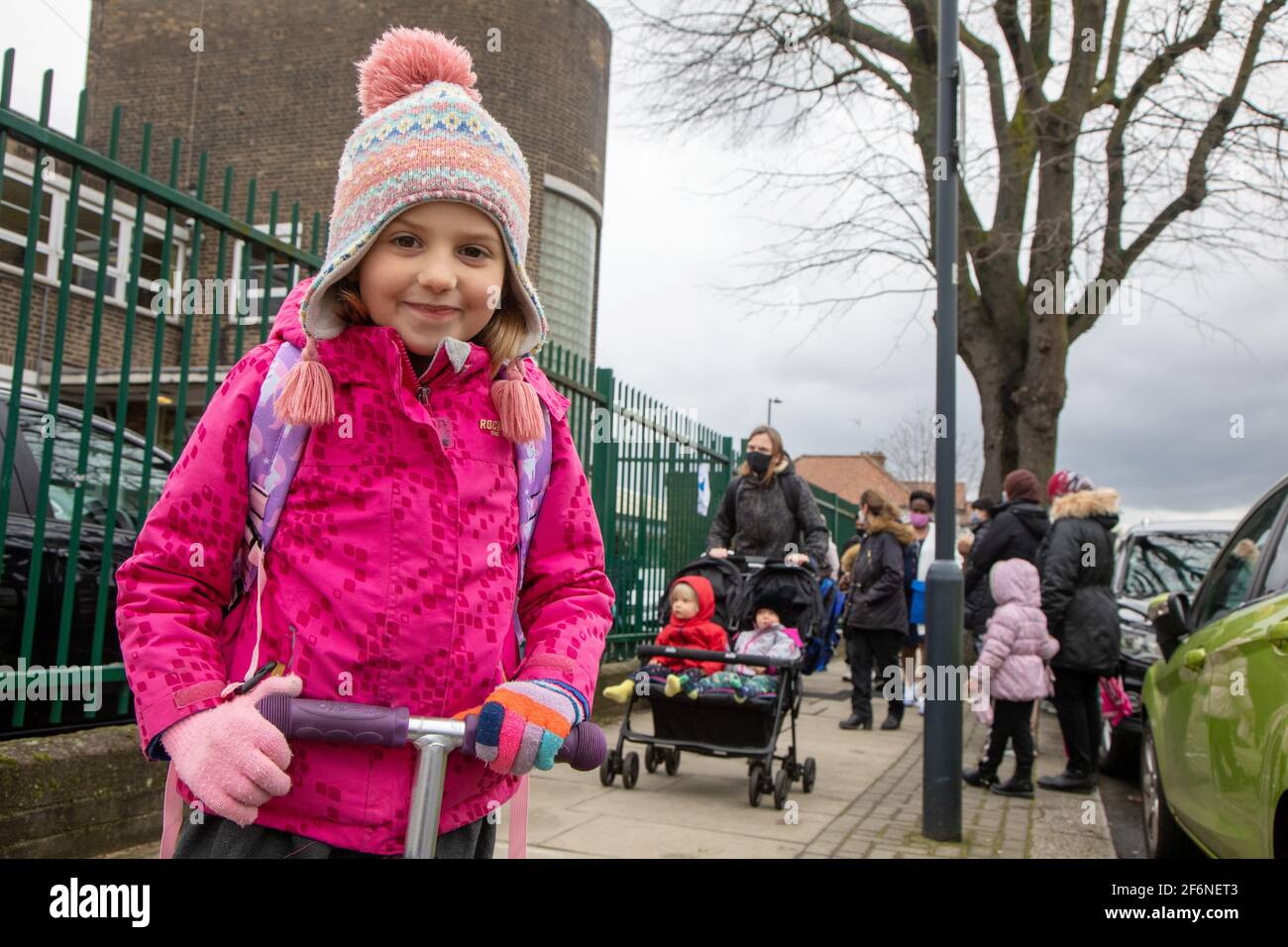 Fünf Jahre altes Mädchen, das zu Hause auf einem Roller außerhalb der Schule ist Stockfoto