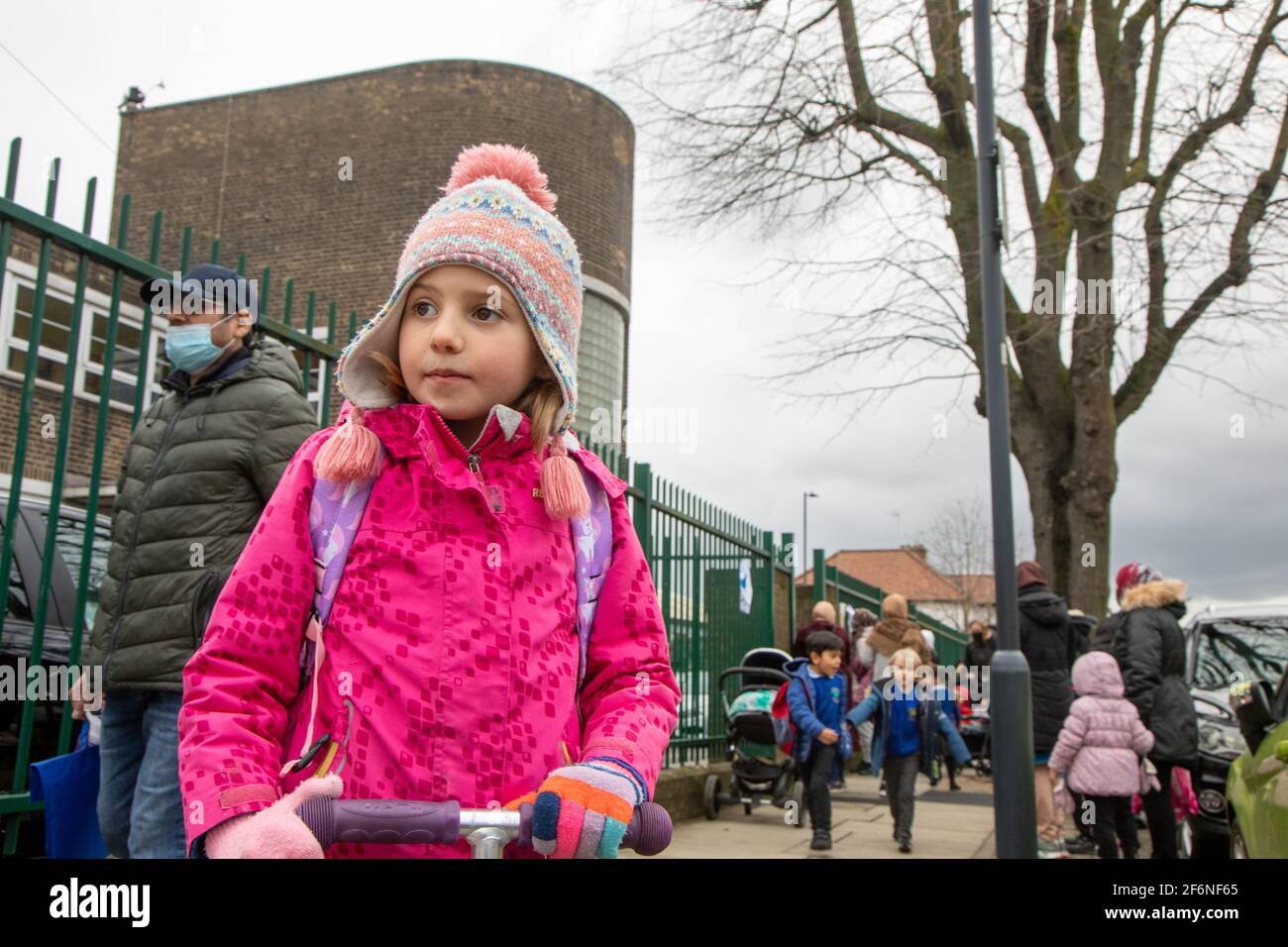 Fünf Jahre altes Mädchen, das zu Hause auf einem Roller außerhalb der Schule ist Stockfoto