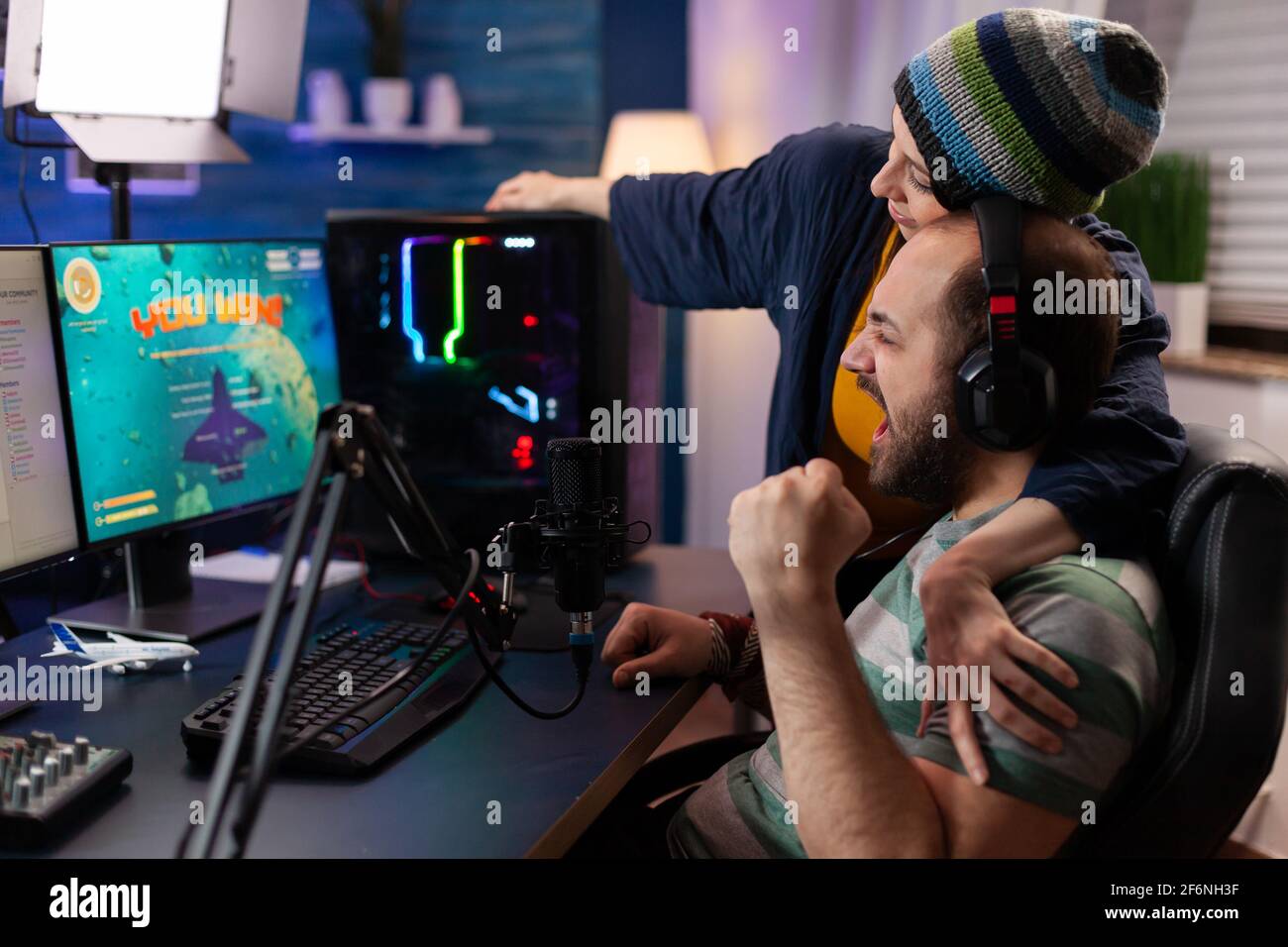 Die Spieler verbinden den Online-Videospielwettbewerb mit professioneller Ausrüstung im Heimstudio. Gamer spielen Videospiele mit neuen Grafiken auf einem leistungsstarken Gaming-Computer mit RGB Stockfoto