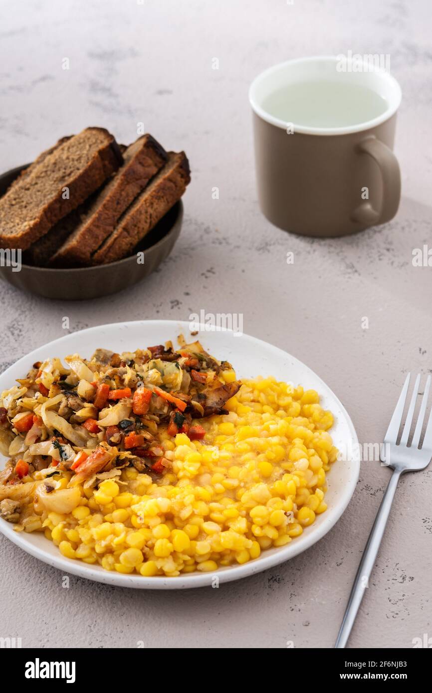 Köstliches herzhaftes Mittagessen, Erbsenbrei mit Kohl, Karotten und Fleischragout Stockfoto