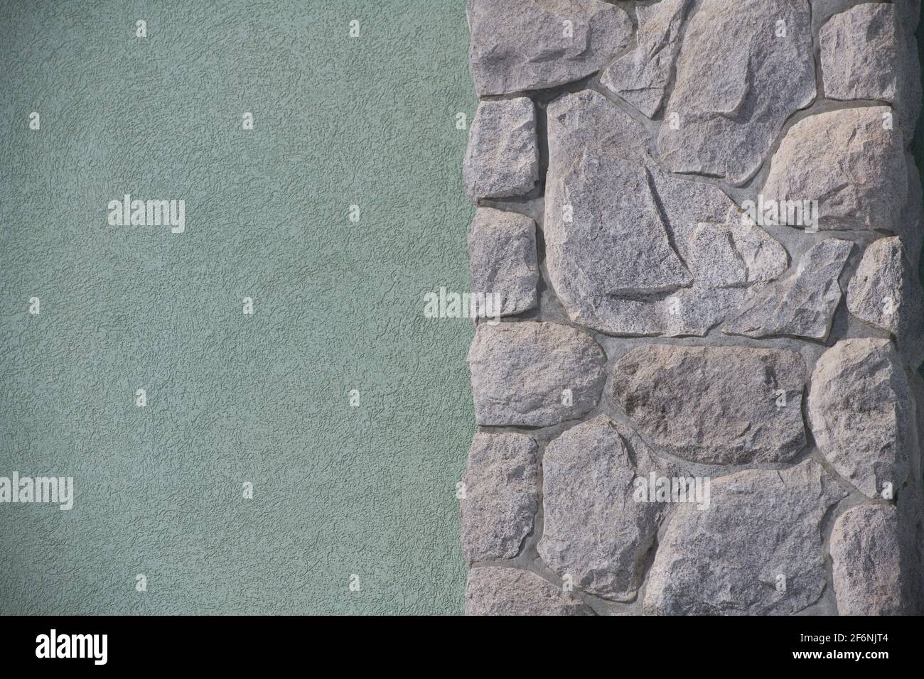 Ungerade geformte Steine oder Felsen passen zusammen wie ein Puzzle, um eine konstruierte Steinmauer Mauerwerk Haus Außenwand Hintergrund Hintergrund oder Tapete zu schaffen Stockfoto