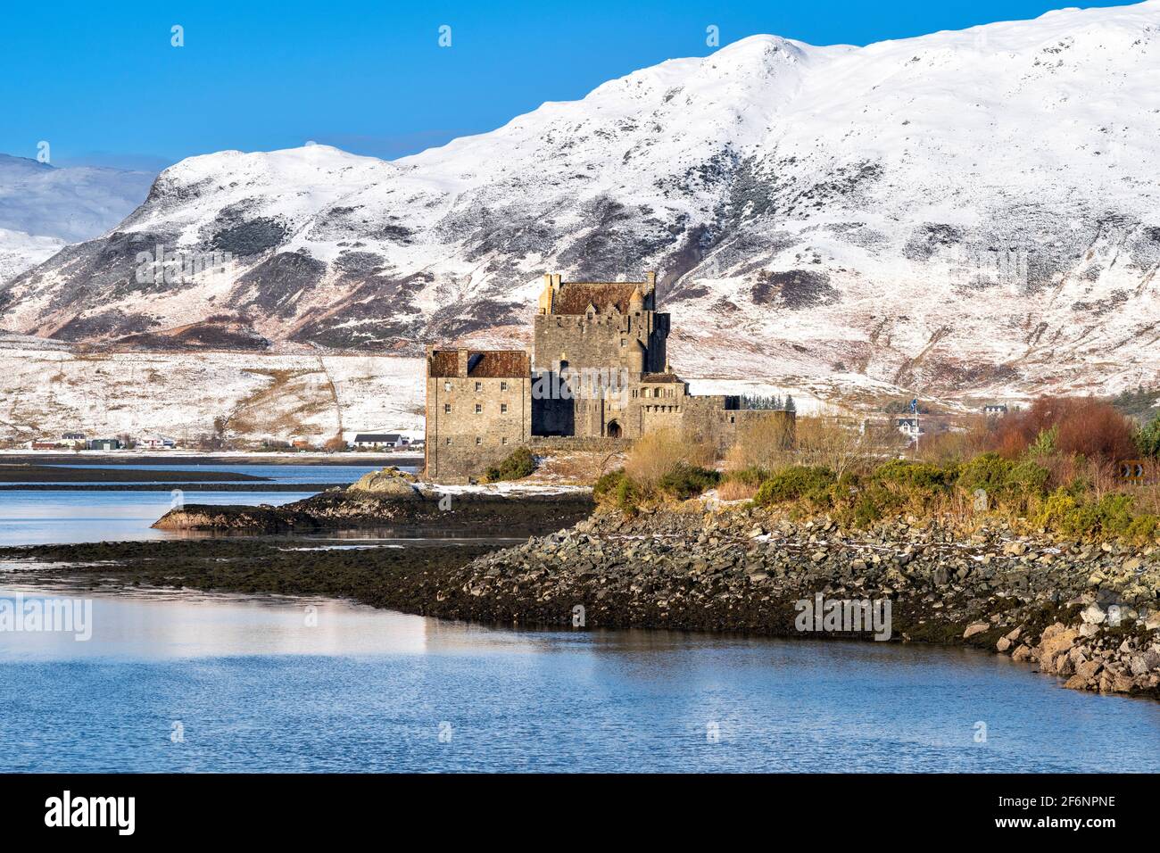 EILEAN DONAN CASTLE LOCH DUICH HIGHLAND SCHOTTLAND DAS SCHOTTISCHE SCHLOSS IM WINTER BEDECKT SCHNEE AUF DEN HÜGELN Stockfoto