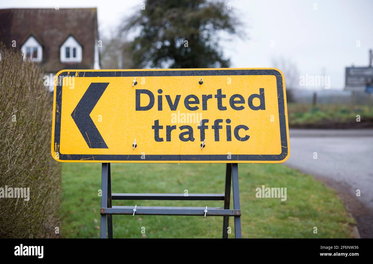 Umgelenkt Verkehrsschild mit Pfeil nach links. Gelbes Straßenschild in Großbritannien in Nahaufnahme, das eine Umleitung oder Umleitung anzeigt. Stockfoto
