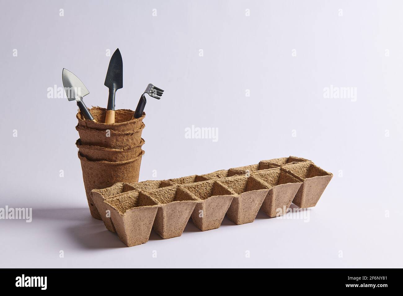 Drei Schaufeln und ein Rechen leeren Töpfe zum Aussaat von Samen Drei Schaufeln und ein Rechen Stockfoto