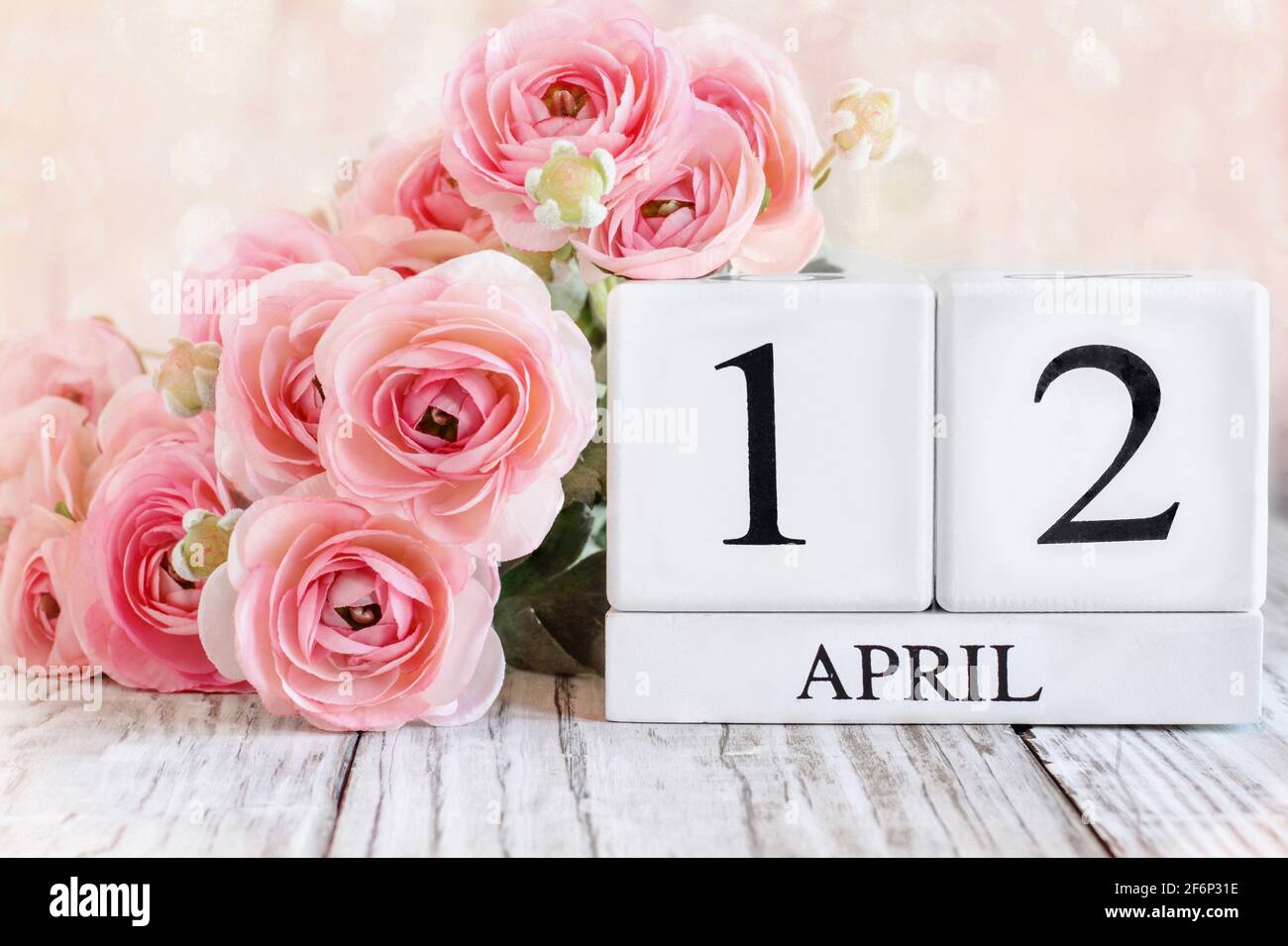 Kalenderblöcke aus weißem Holz mit dem Datum 12. April zur Feier des Ostersonntages. Selektiver Fokus mit unscharfem Hintergrund. Stockfoto